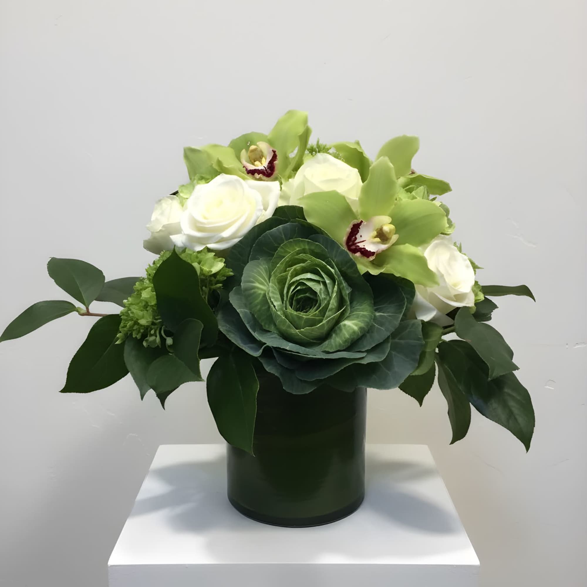 A mix of brightly colored greens accompanied by white roses, green hydrangea