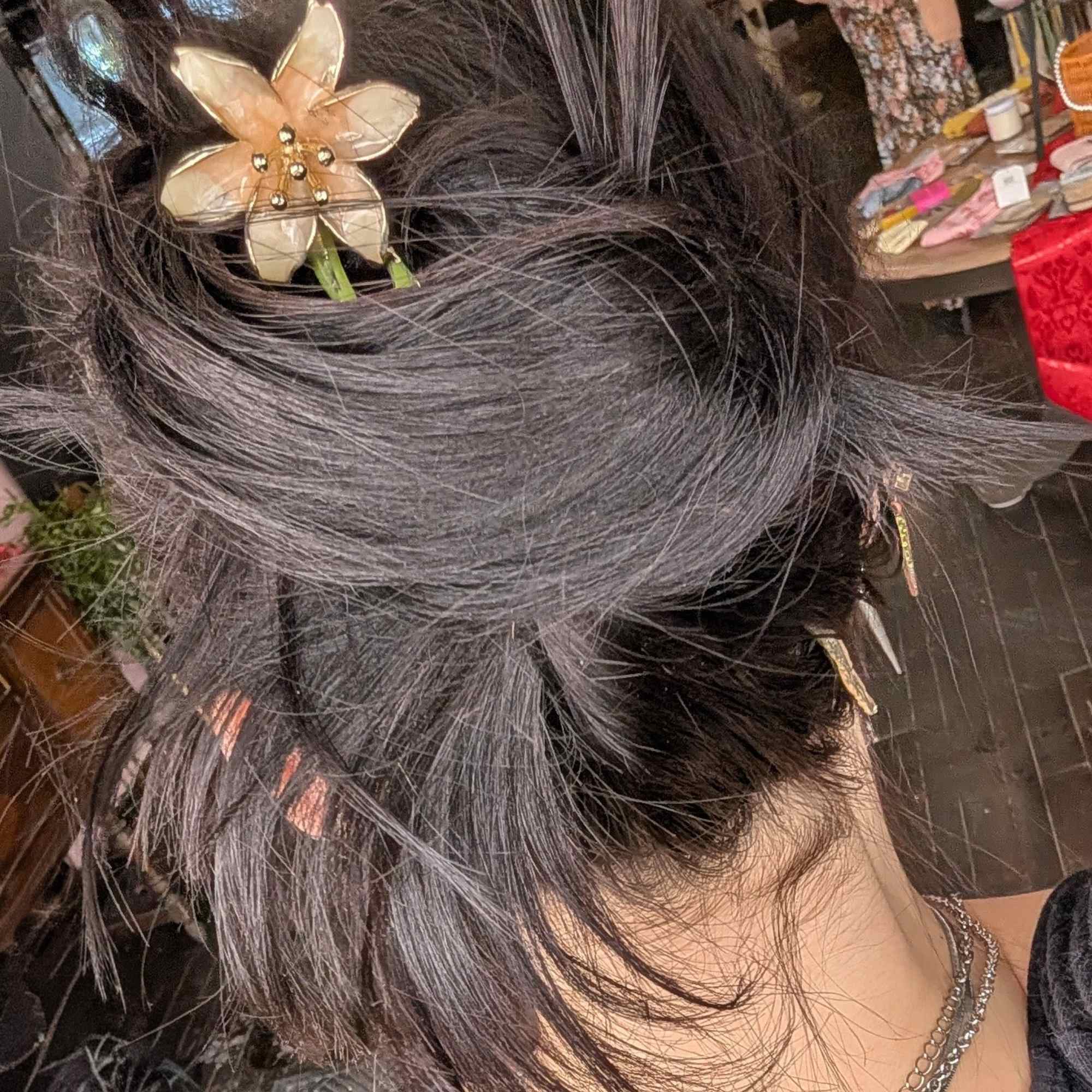Hair styled with a gold flower hair clip