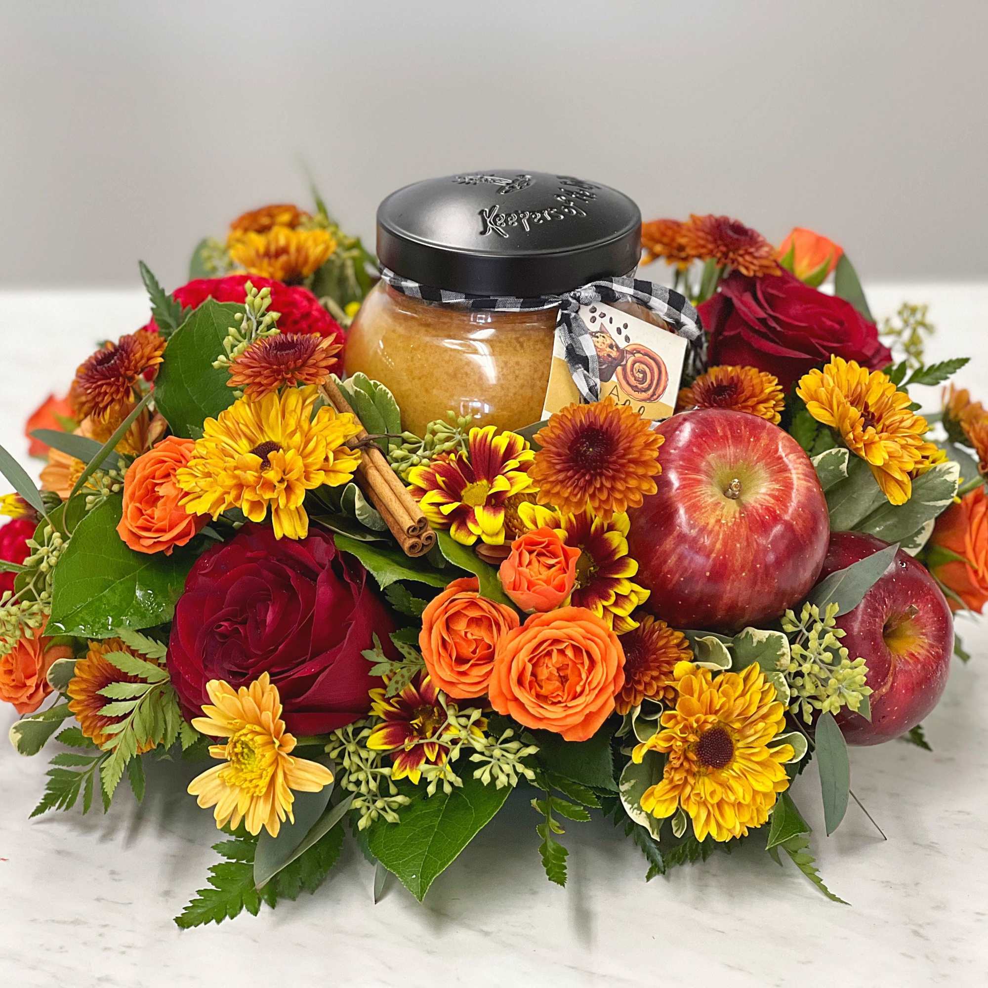 Autumn floral gift arrangement with apples and a jar of honey