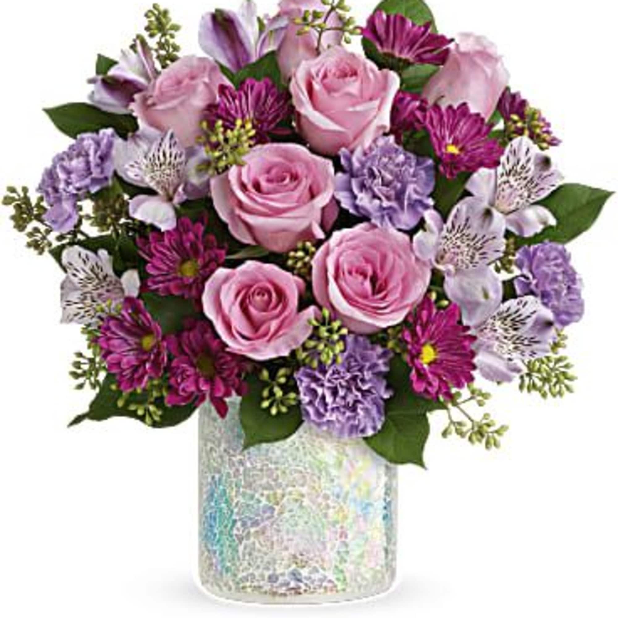 Pink roses and purple flowers arranged in a iridescent vase