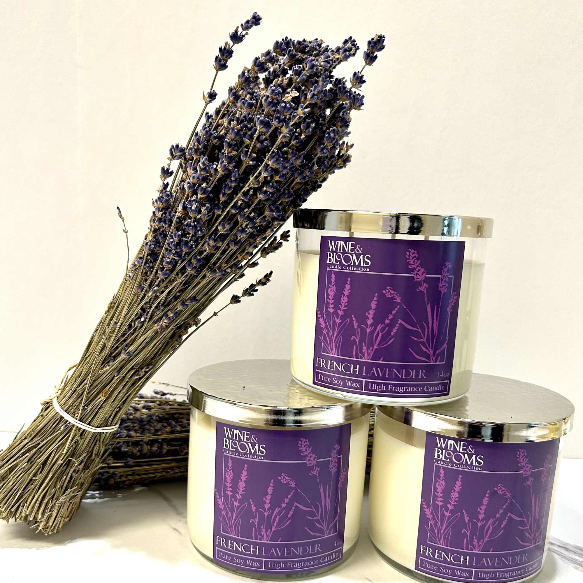 Bundle of dried lavender beside three lavender candles