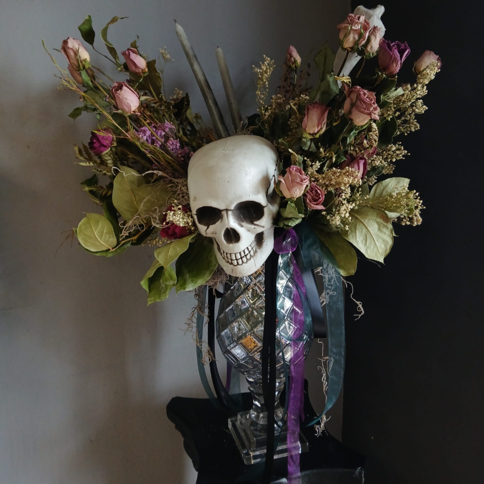 Skull centerpiece with pink roses and ribbons in a clear vase