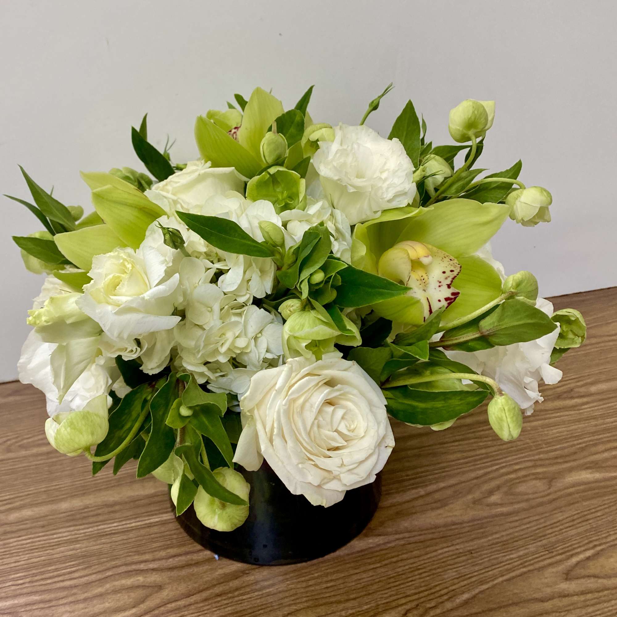 White and green floral arrangement in a black vase, photo 2 of 2