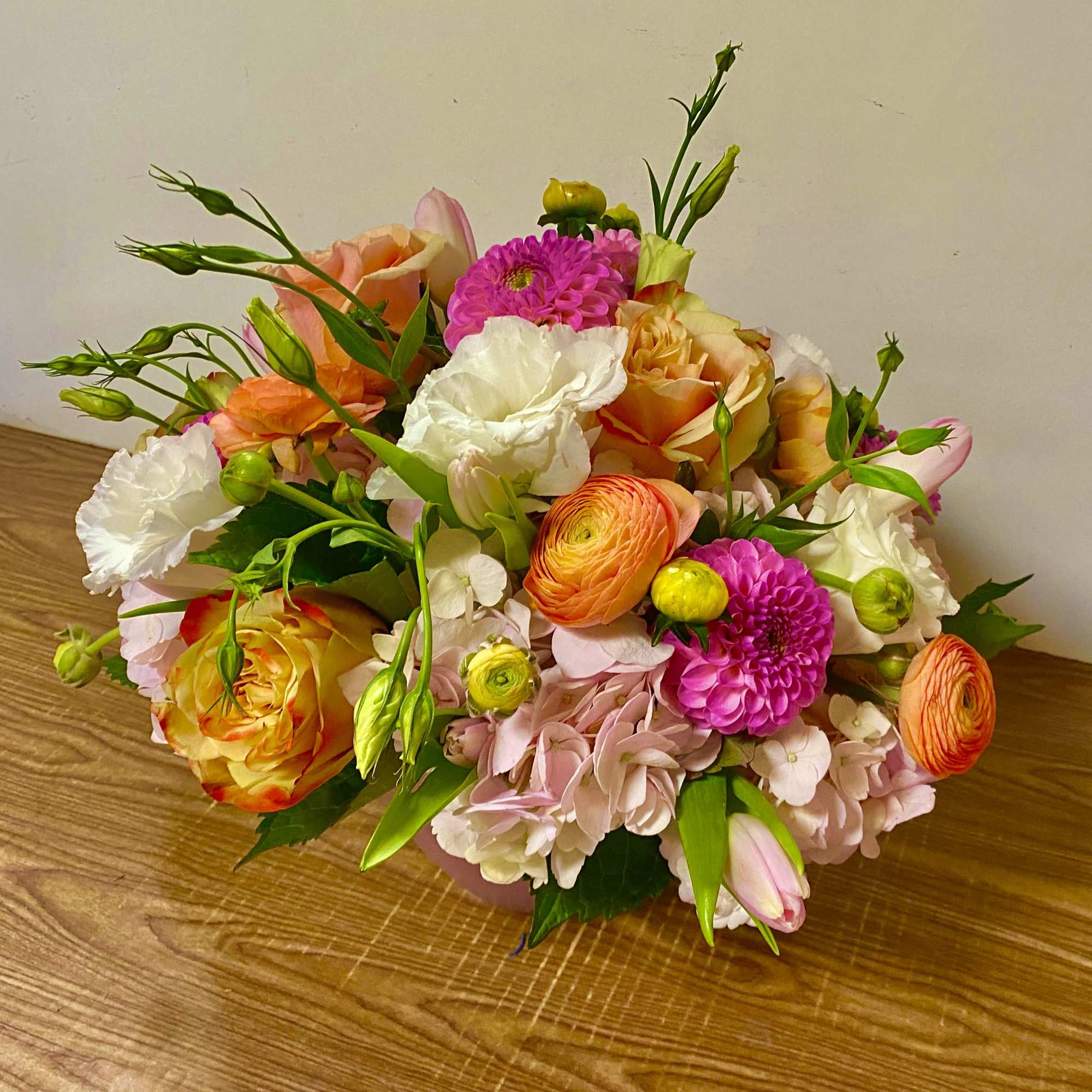 Mixed bouquet of pink, orange, and white flowers on a table
