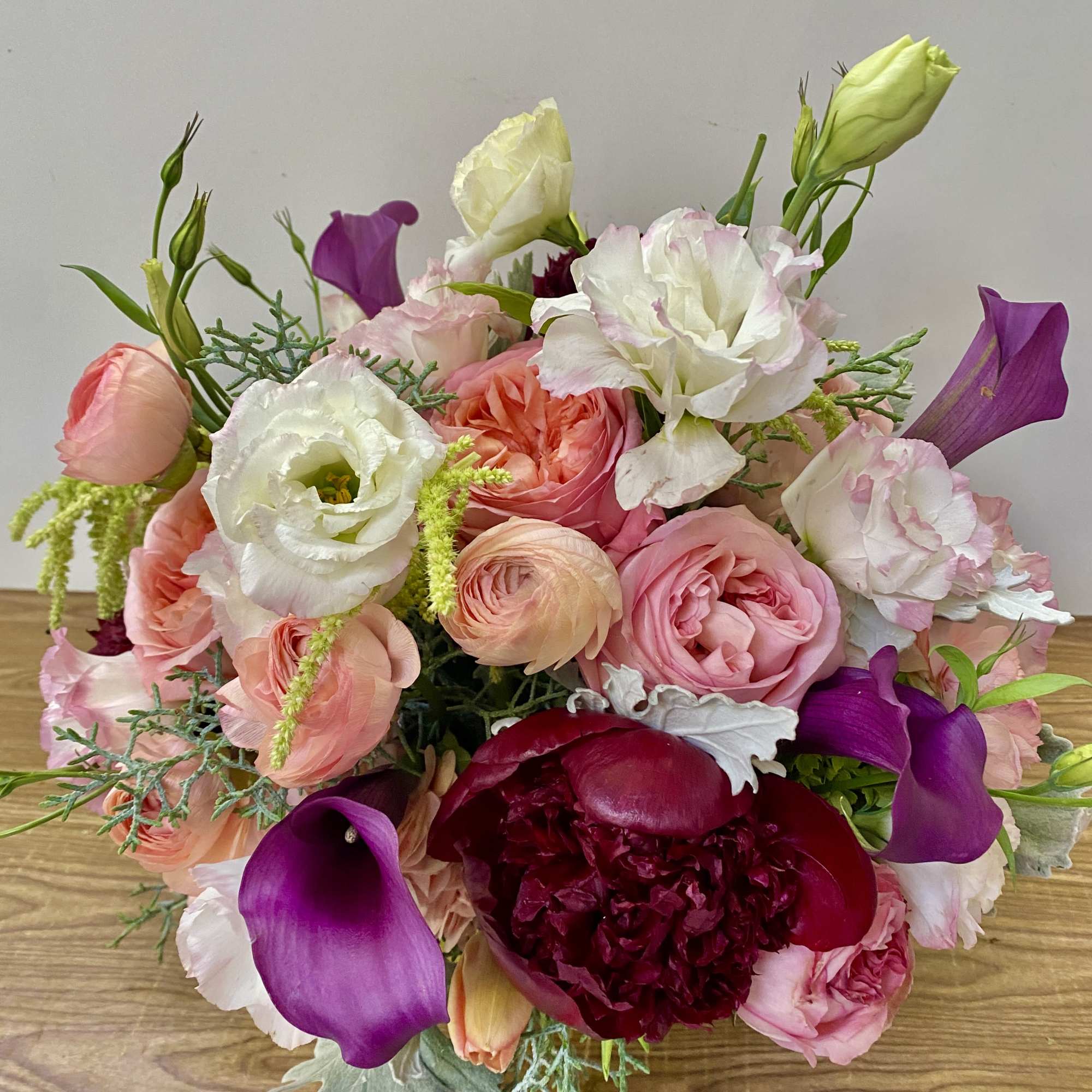 Bouquet of pink, white, and purple flowers with calla lilies and roses