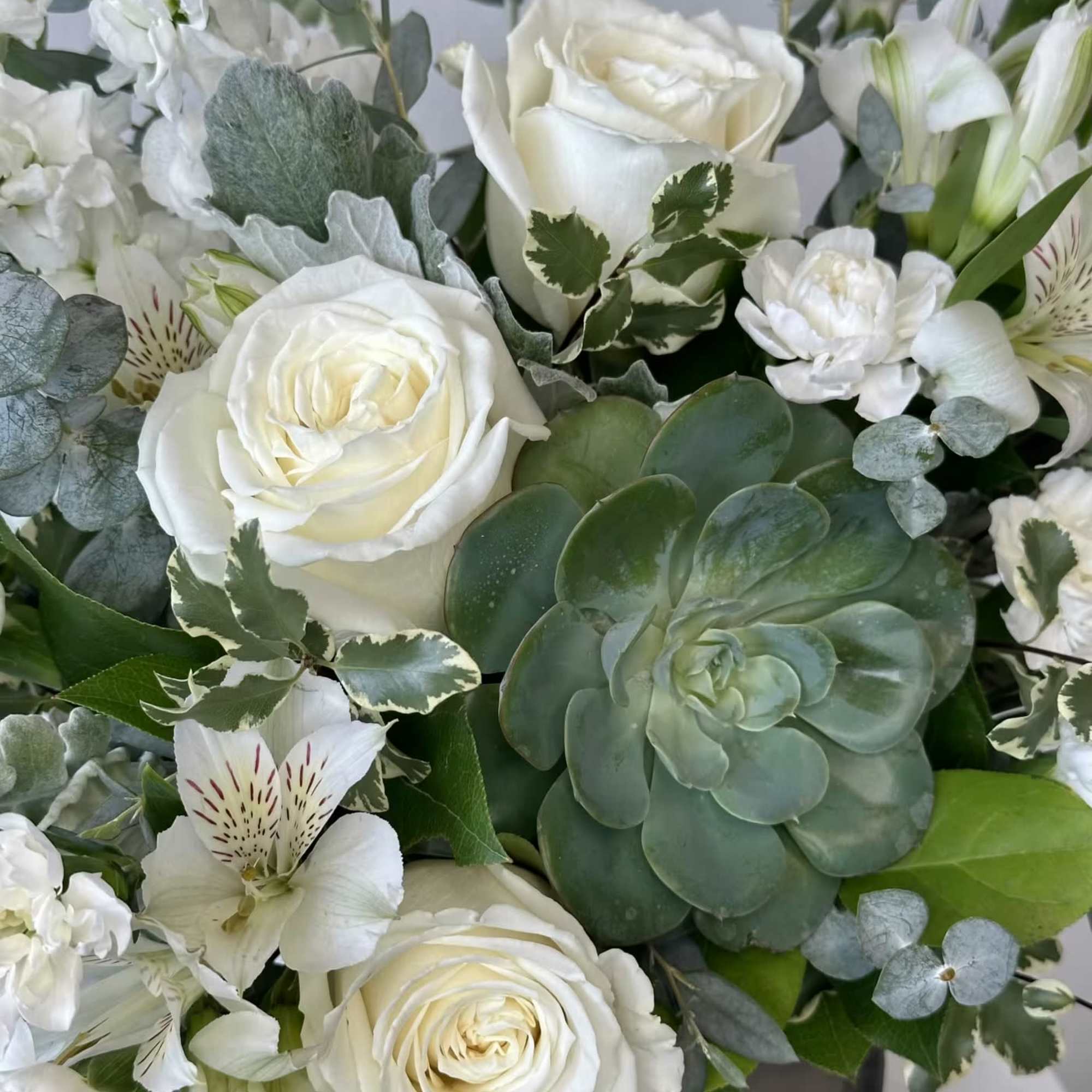 White roses and alstroemeria with a succulent and eucalyptus