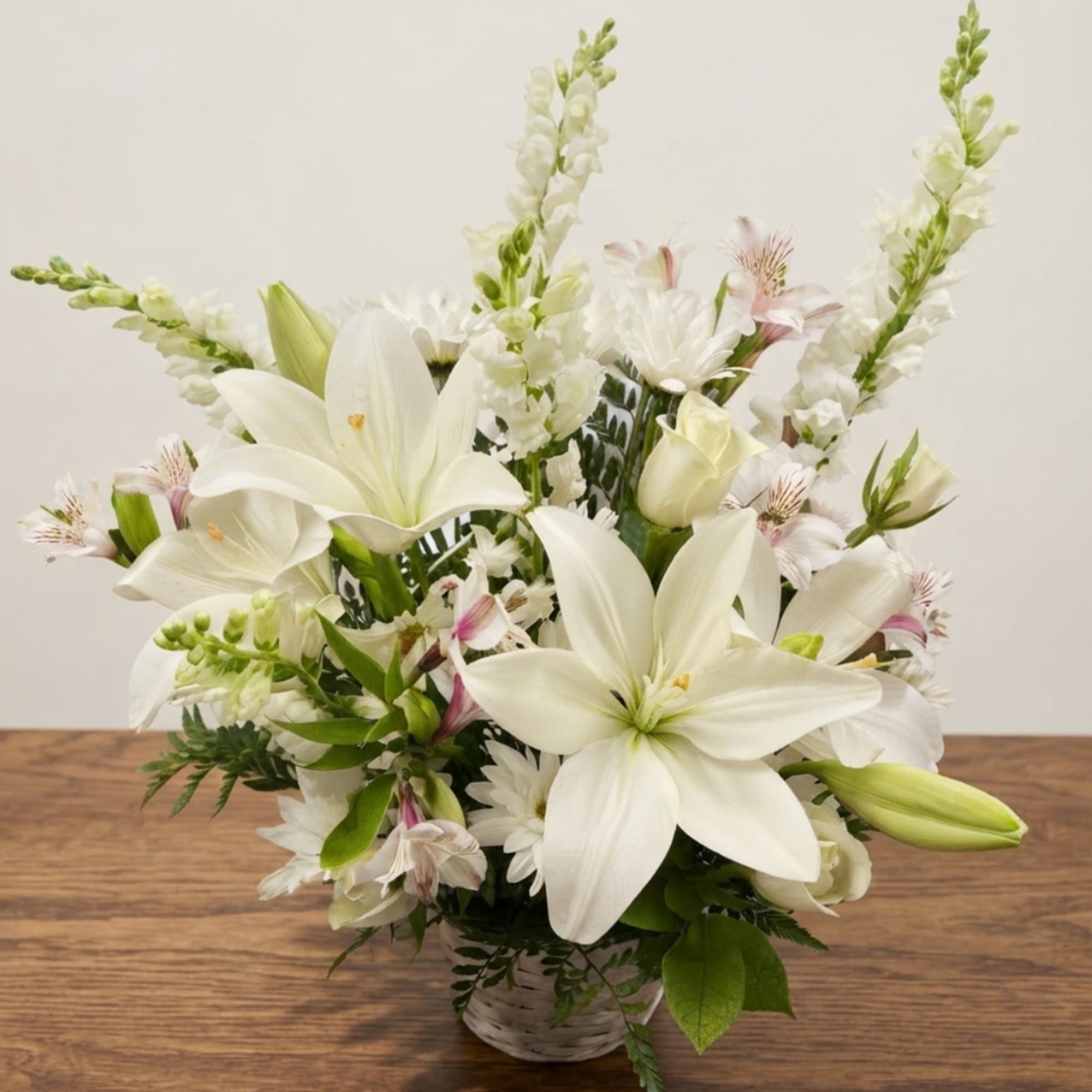 White lilies and mixed white flowers in a glass vase