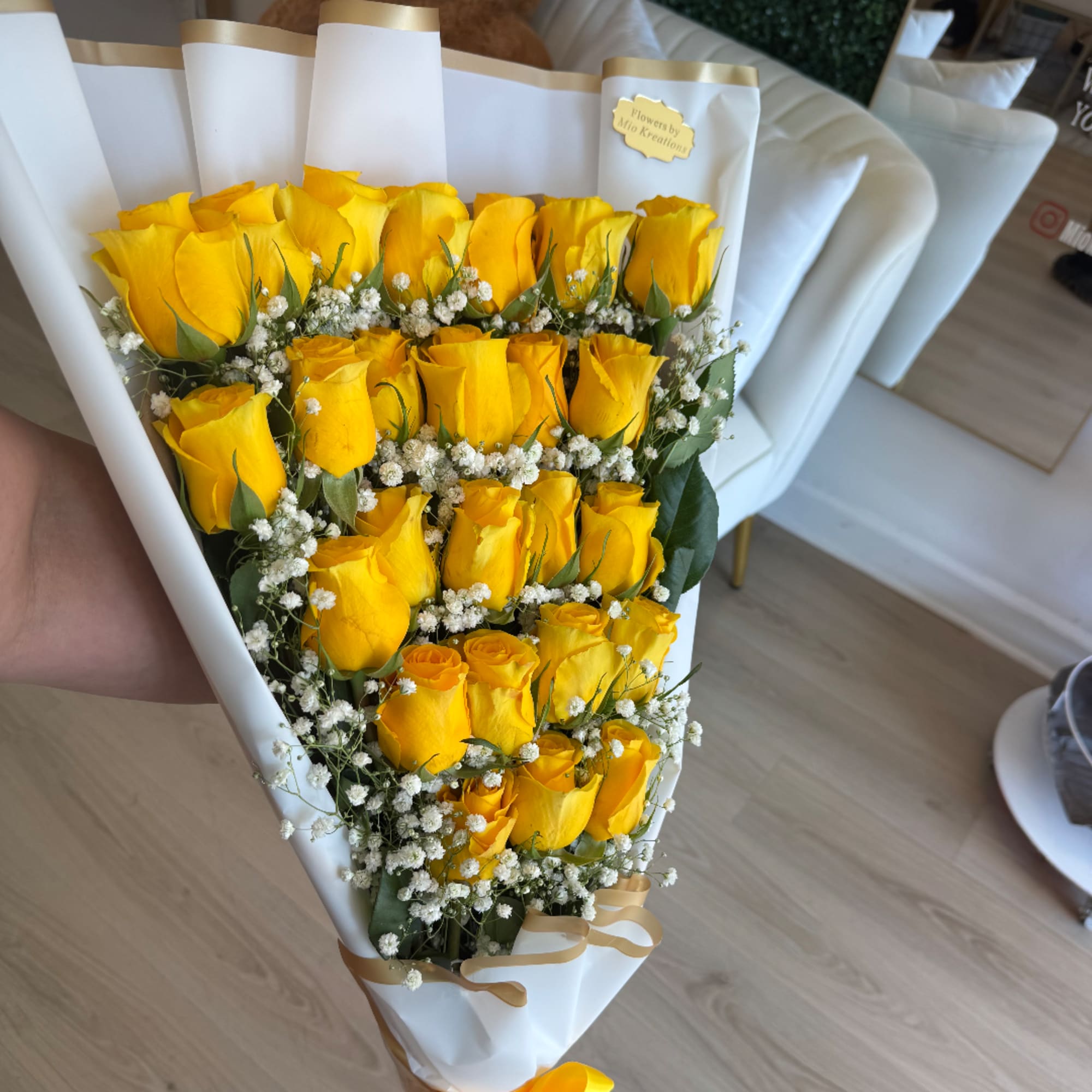 Bouquet of yellow roses with baby's breath in white wrap