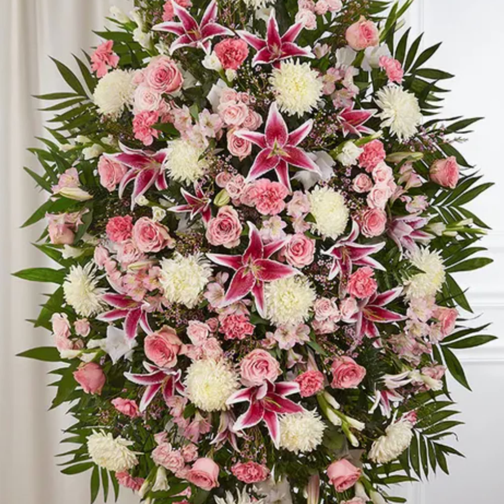 Large pink and white funeral spray with lilies, roses, and carnations