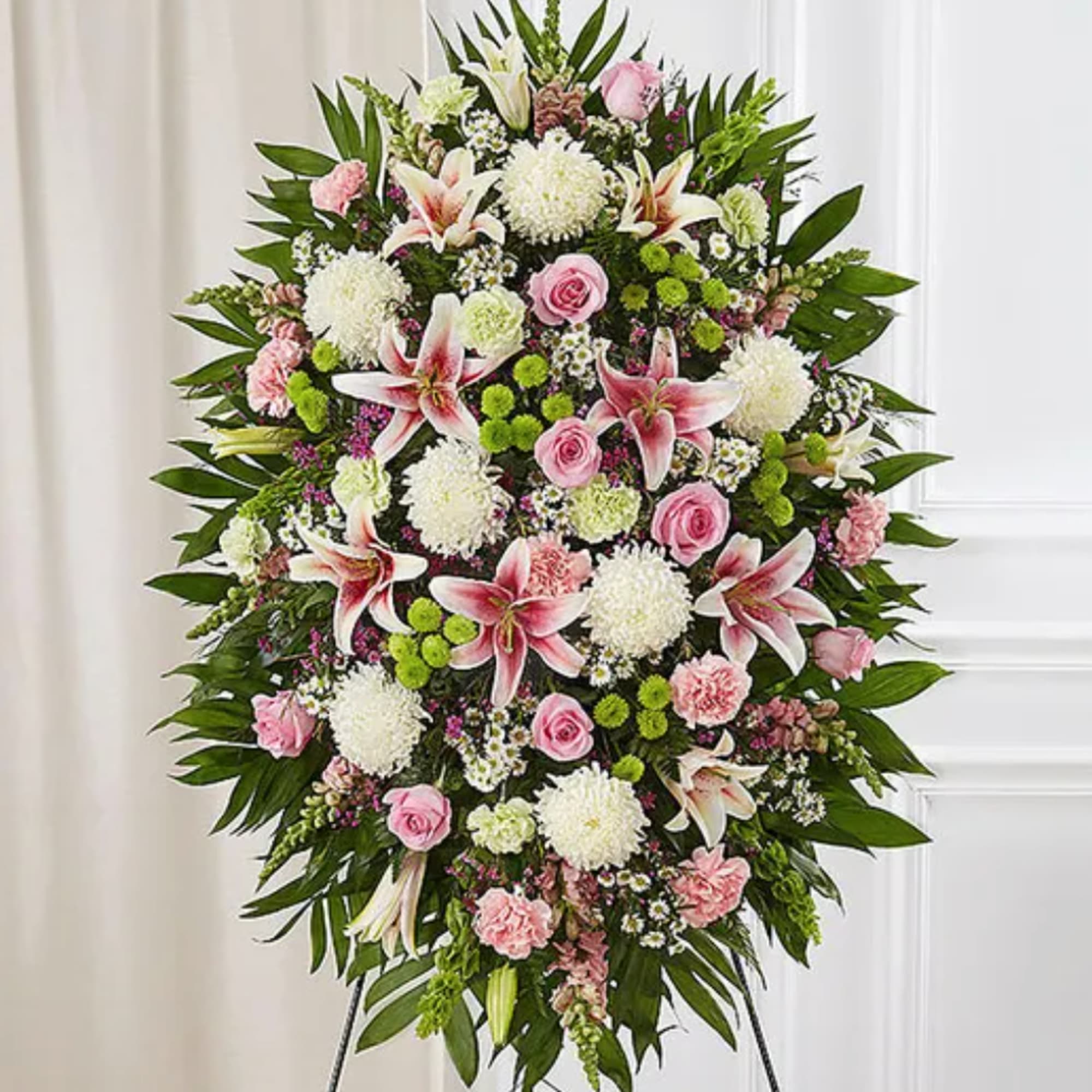 Standing floral spray with pink roses, lilies, and white mums on an easel