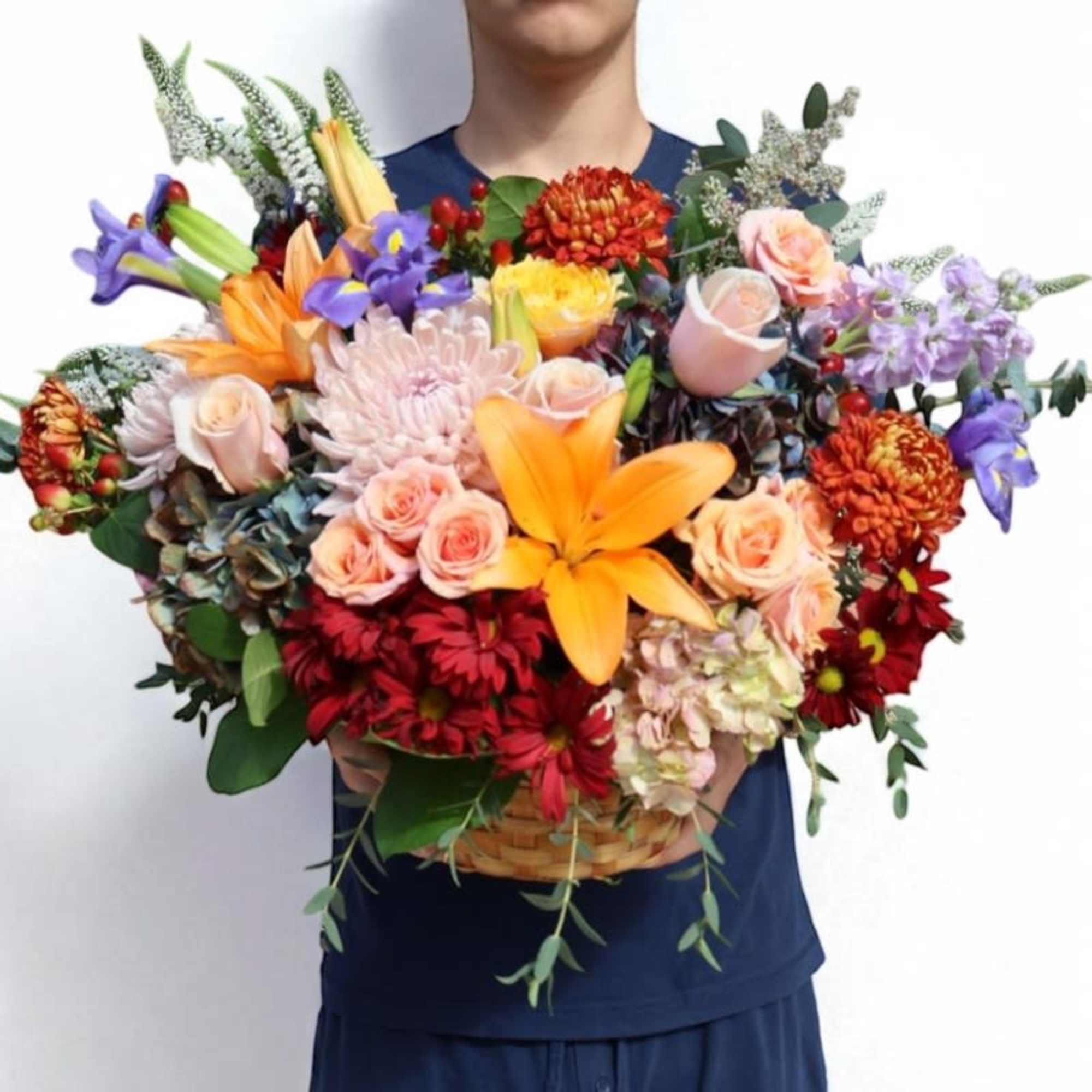 Large mixed bouquet in a basket with lilies, roses, and chrysanthemums