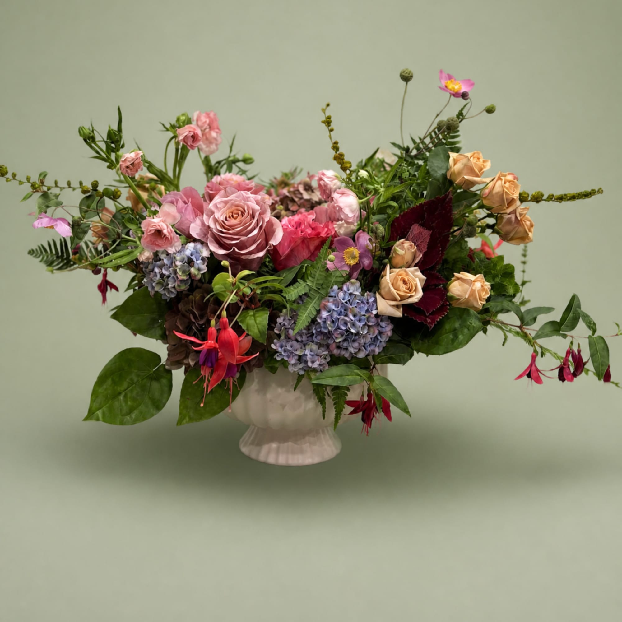 Mixed bouquet of pink and peach flowers in a white vase