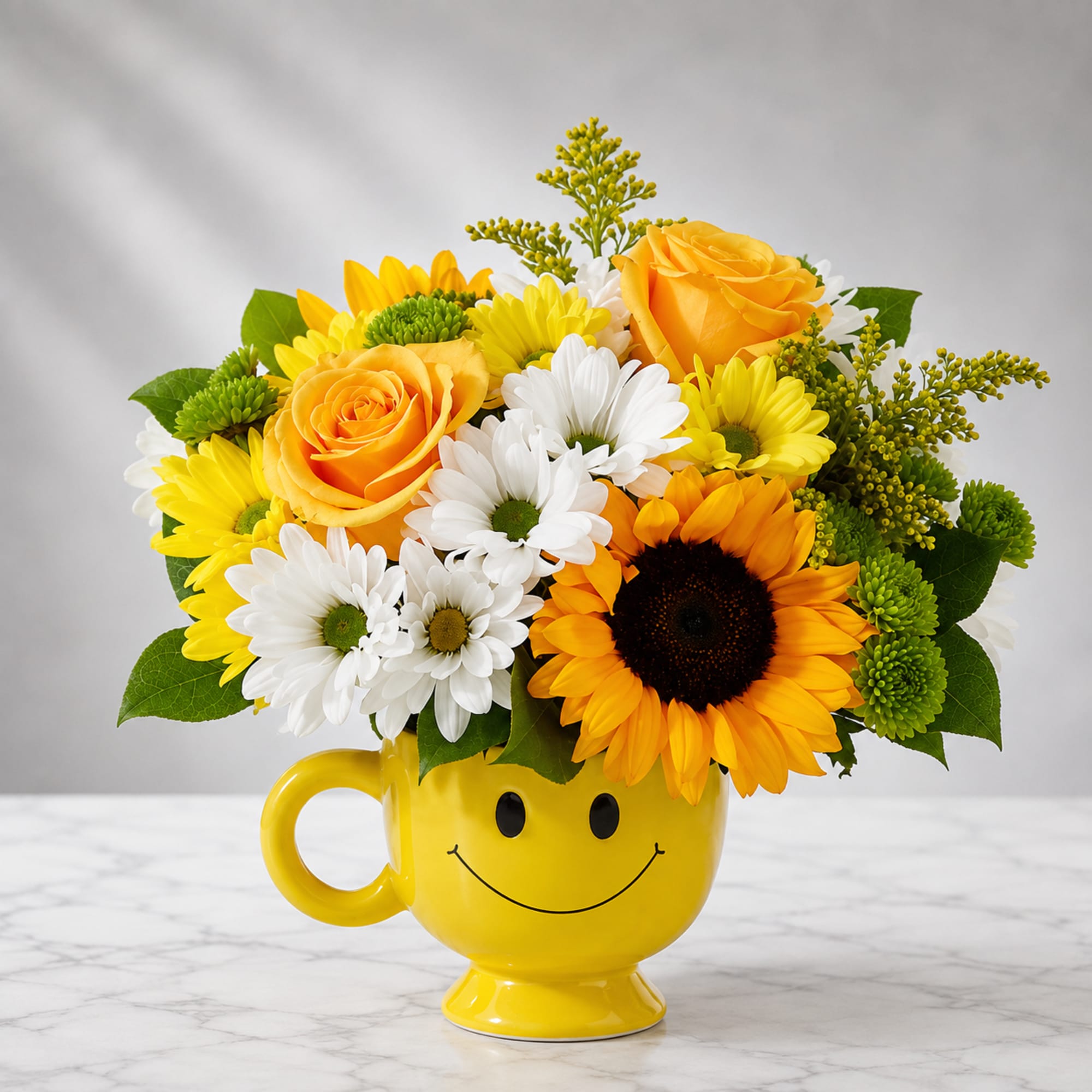 Yellow mug vase with a smiley face holding yellow, white, and orange flowers