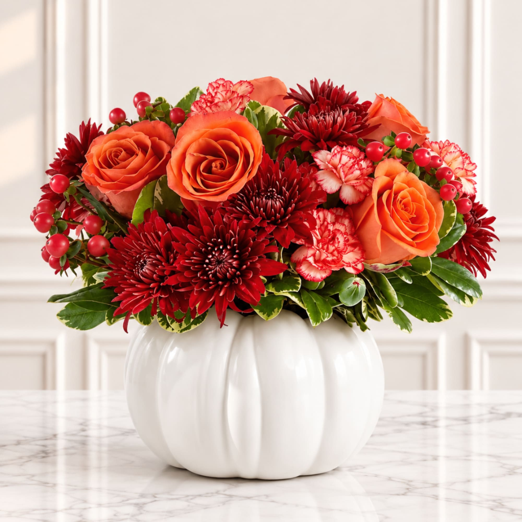 Orange roses and red chrysanthemums arranged in a white pumpkin vase