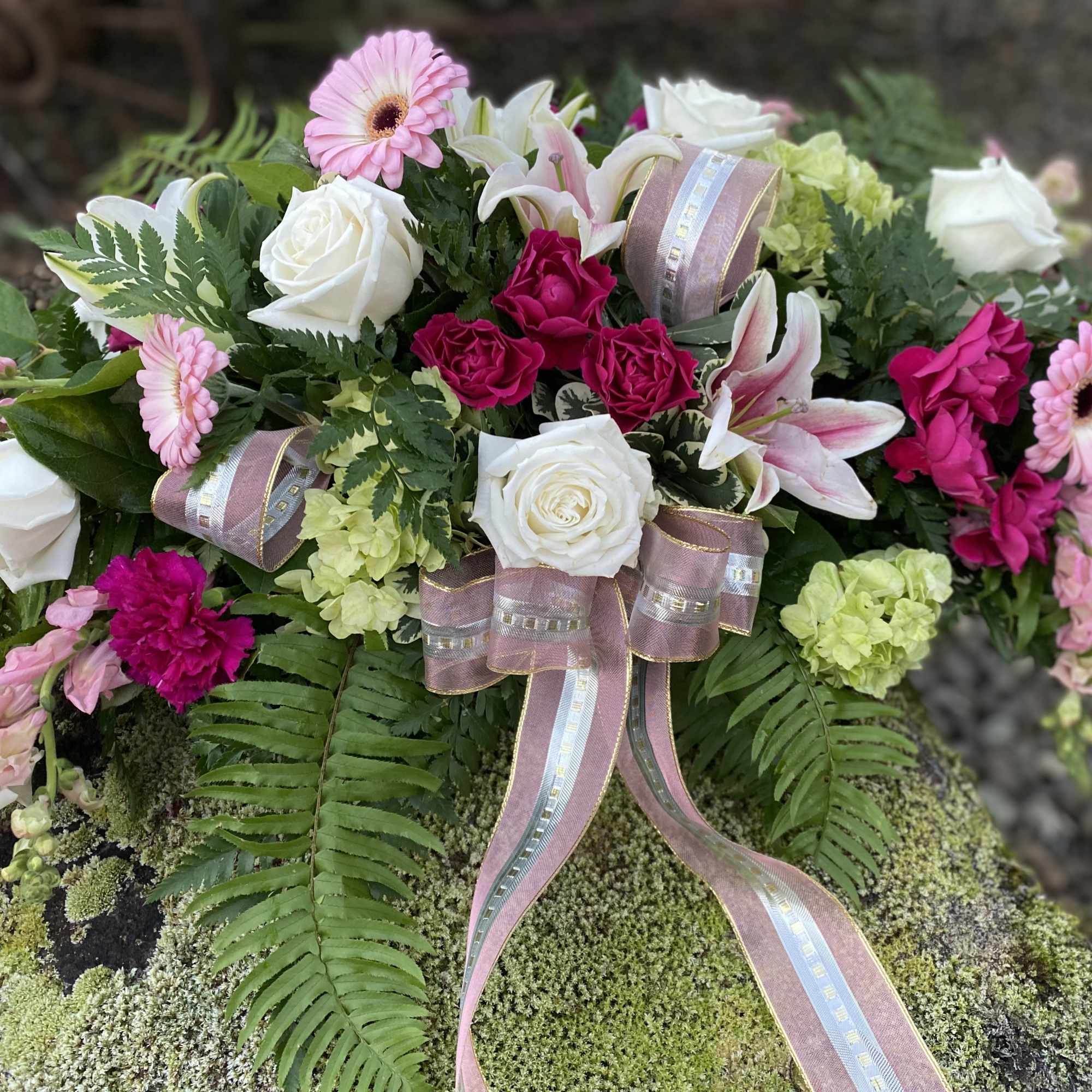 Pink and white floral arrangement with roses, lilies, and gerbera daisies