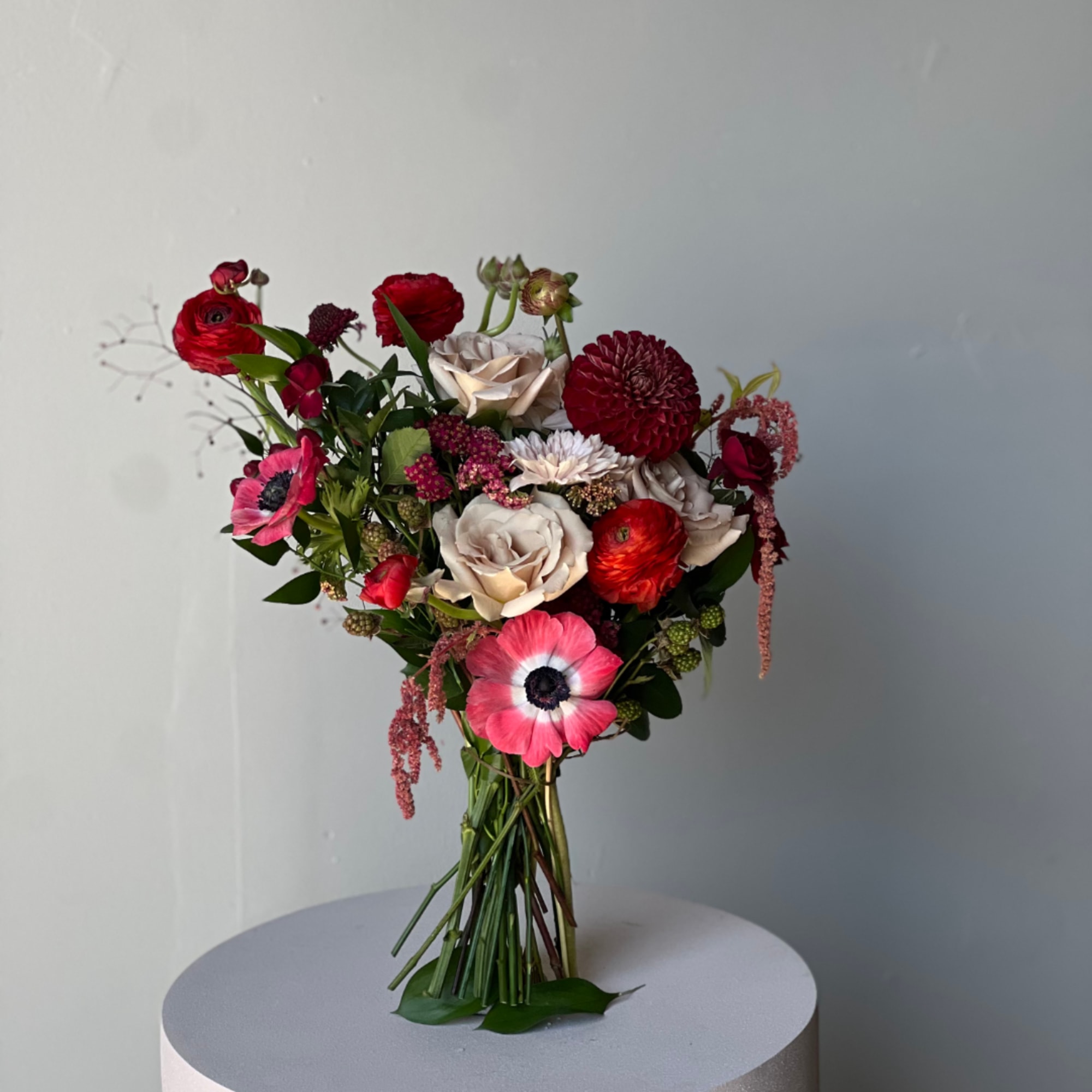 Bouquet of red, pink, and cream flowers tied at the stems
