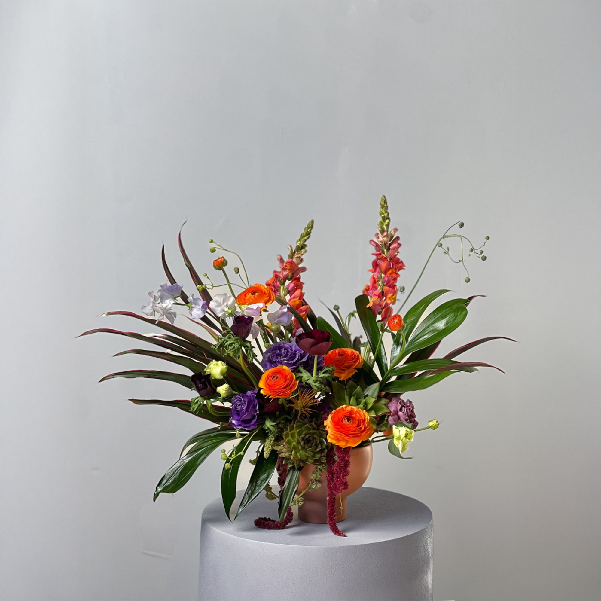 Colorful mixed flower arrangement in a round vase