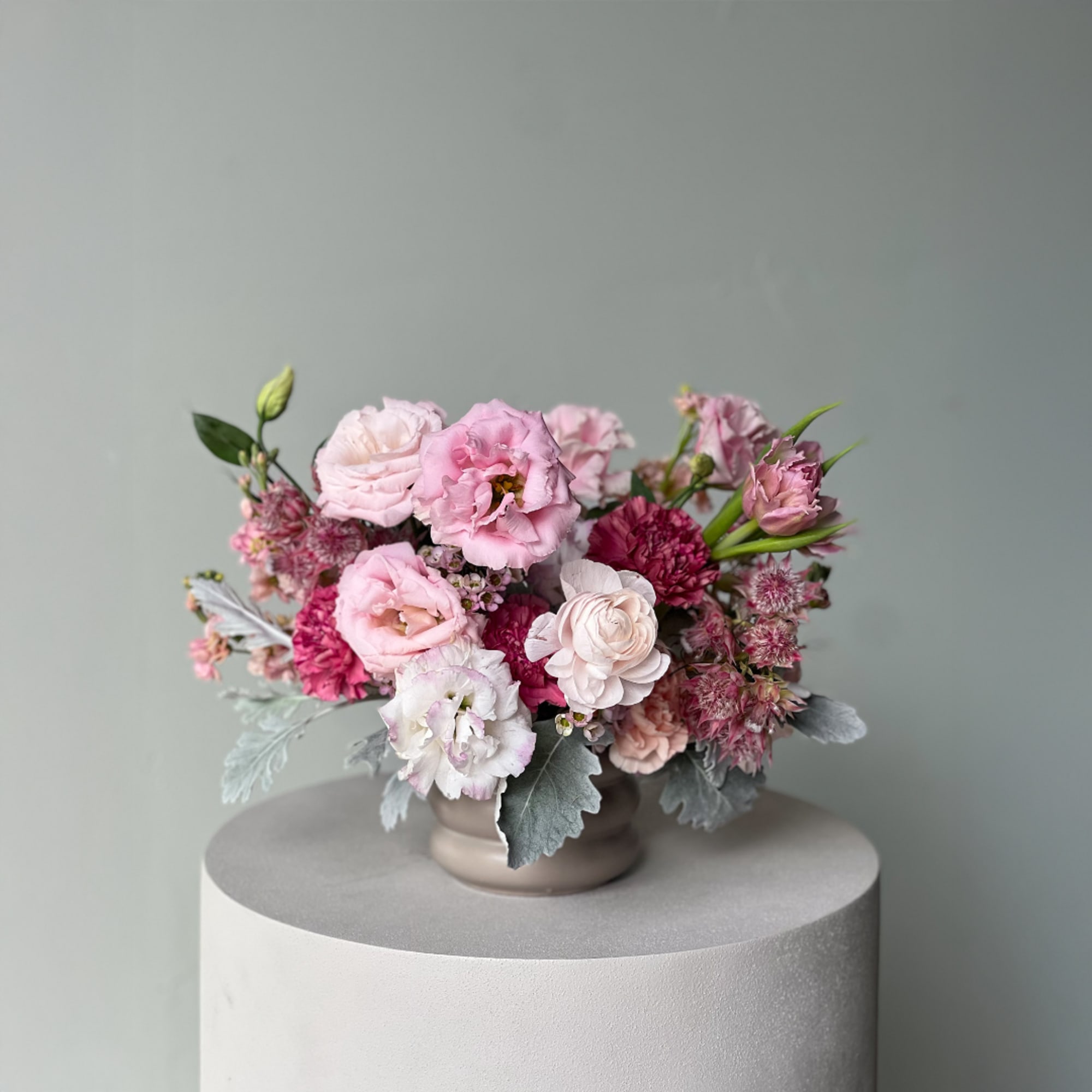 Pink and white floral arrangement in a low ceramic vase