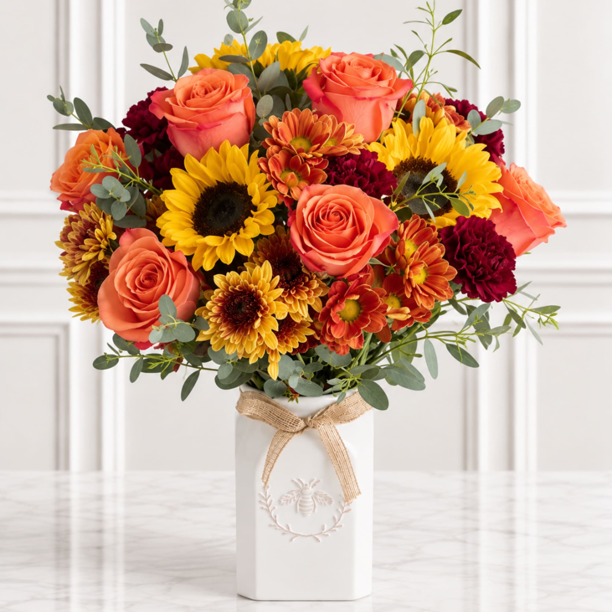 Bouquet of orange roses and yellow sunflowers in a white vase