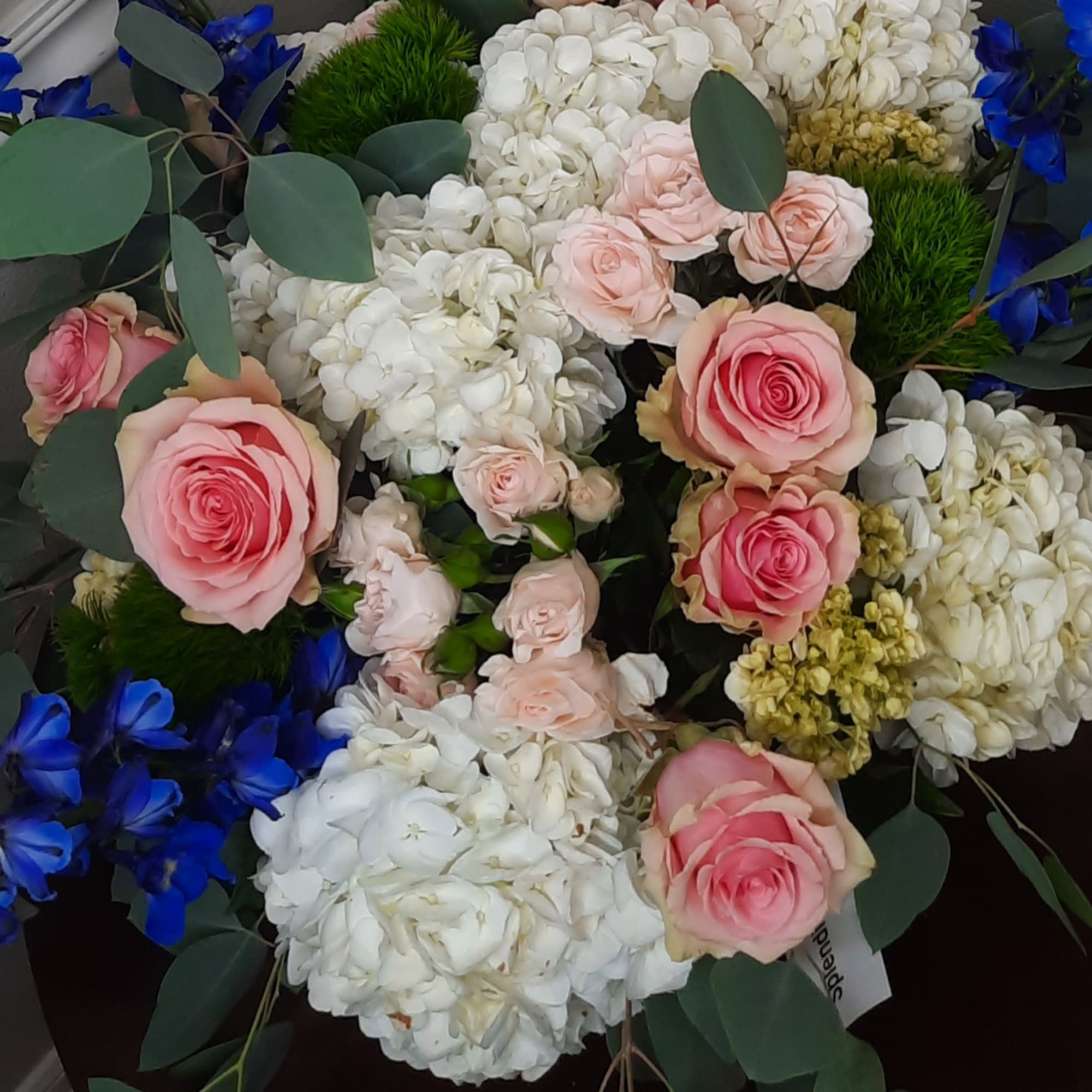 Pink roses with white hydrangeas and blue flowers in a bouquet