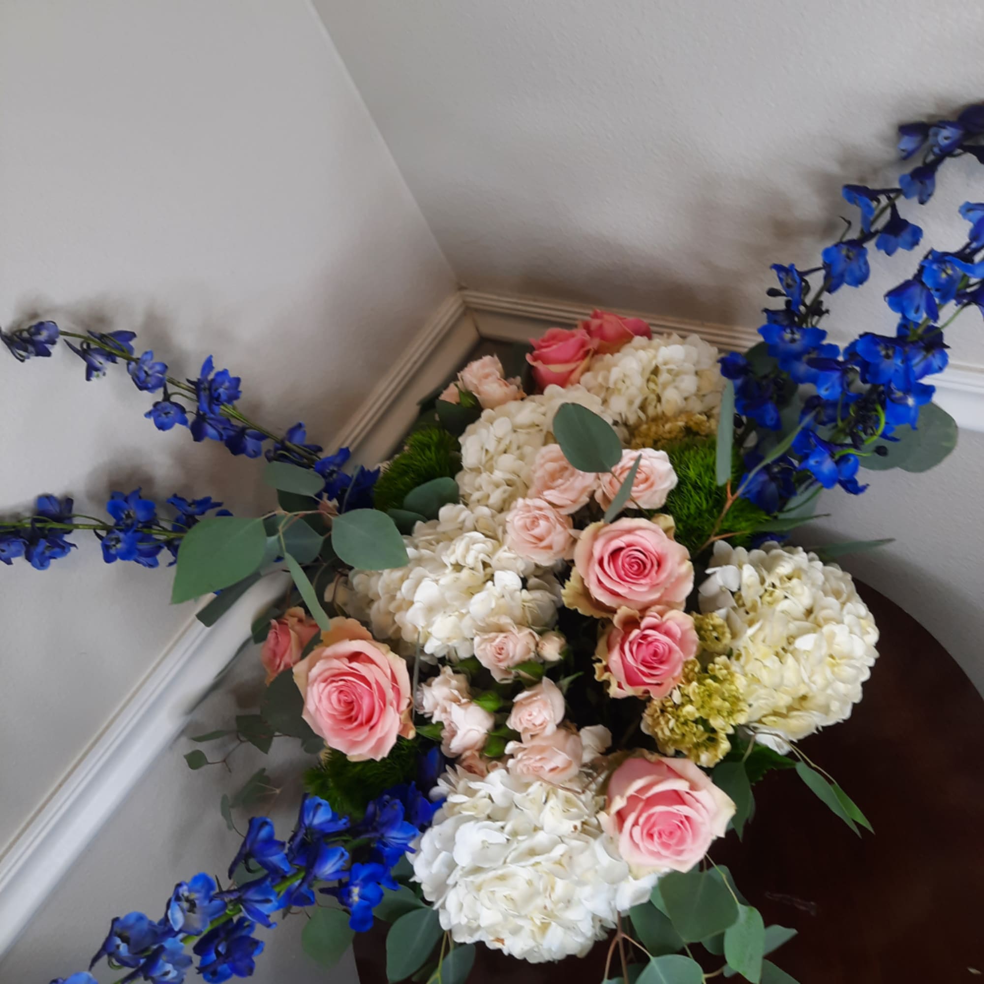 Pink roses and white hydrangeas with blue flowers in a vase
