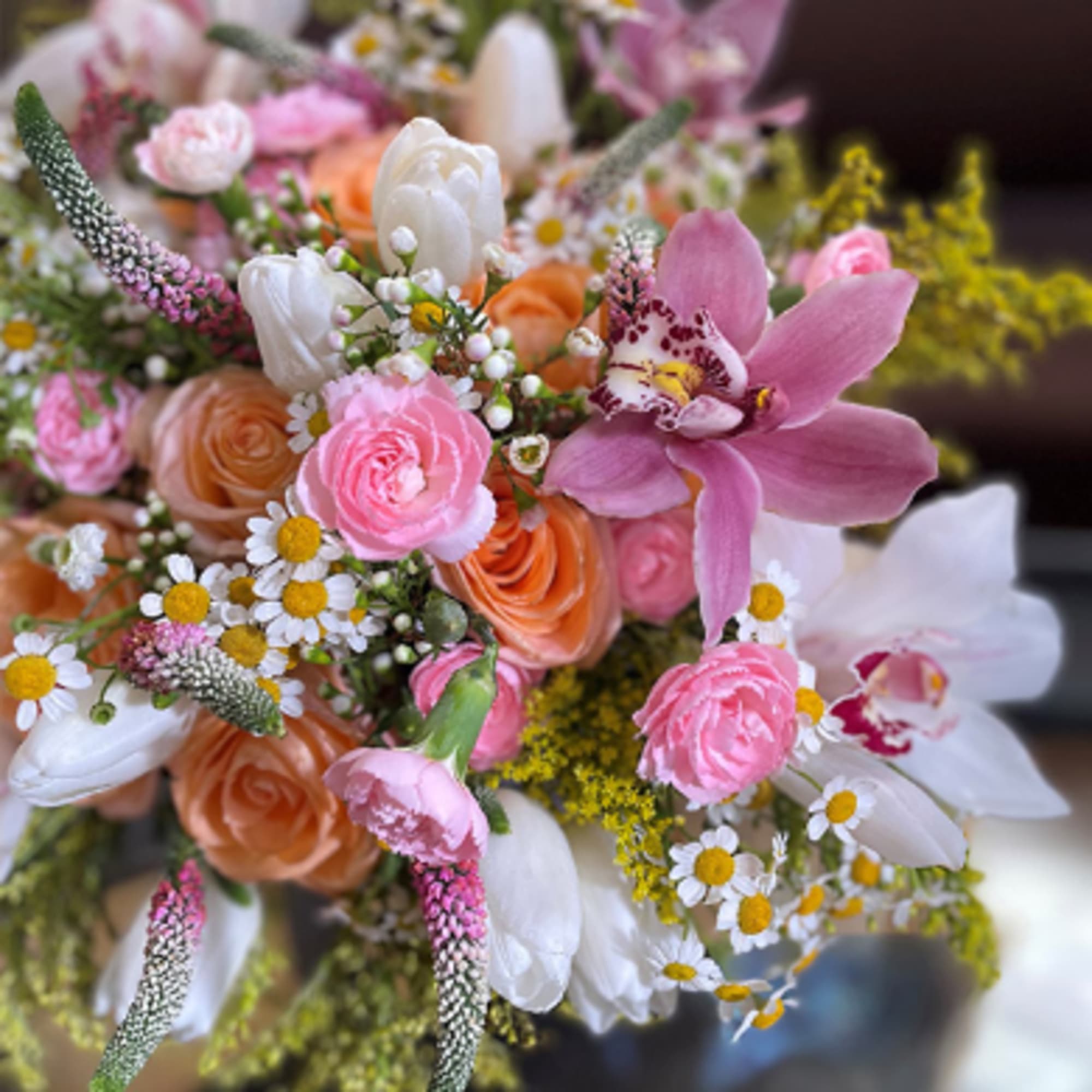 Bouquet of pink, white, and peach flowers with a large pink orchid