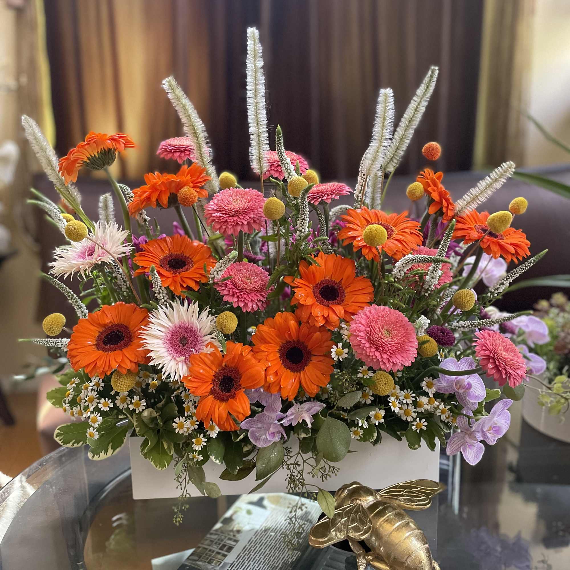 Bright mixed flower arrangement in a white rectangular container