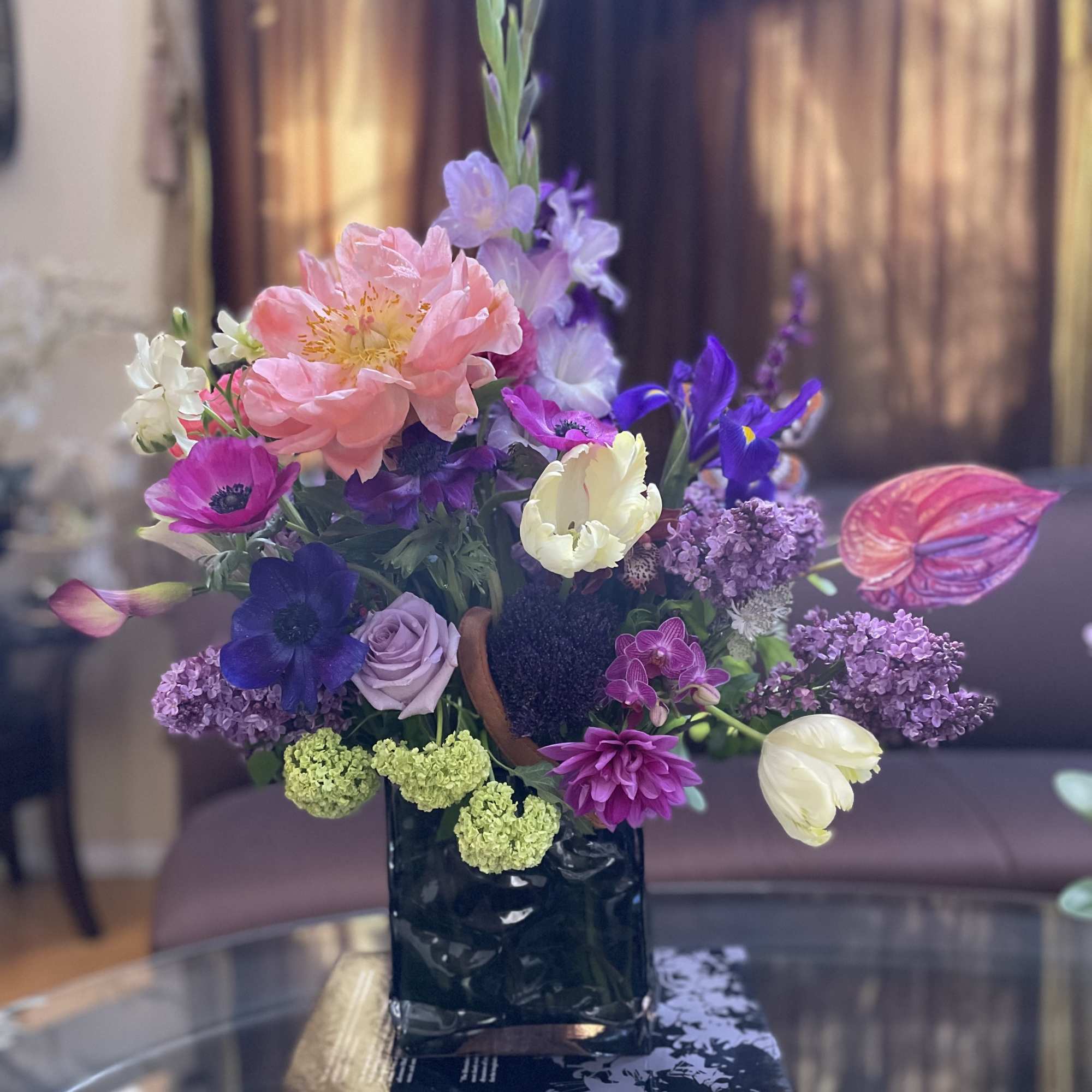 Colorful mixed flower arrangement in a dark vase