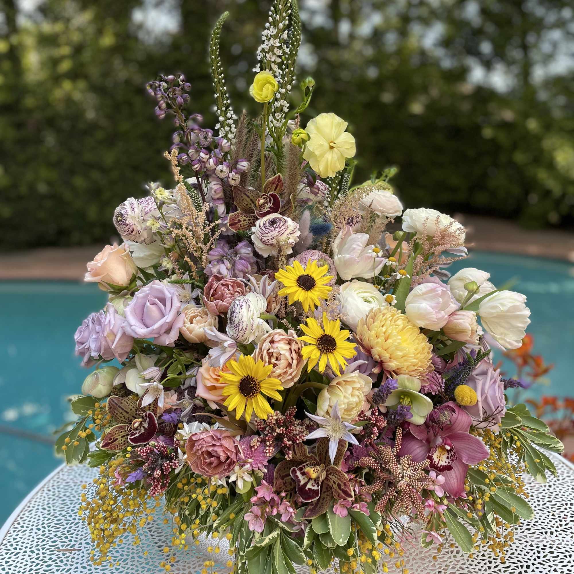 Large mixed bouquet with pastel flowers and tall spikes in a low container