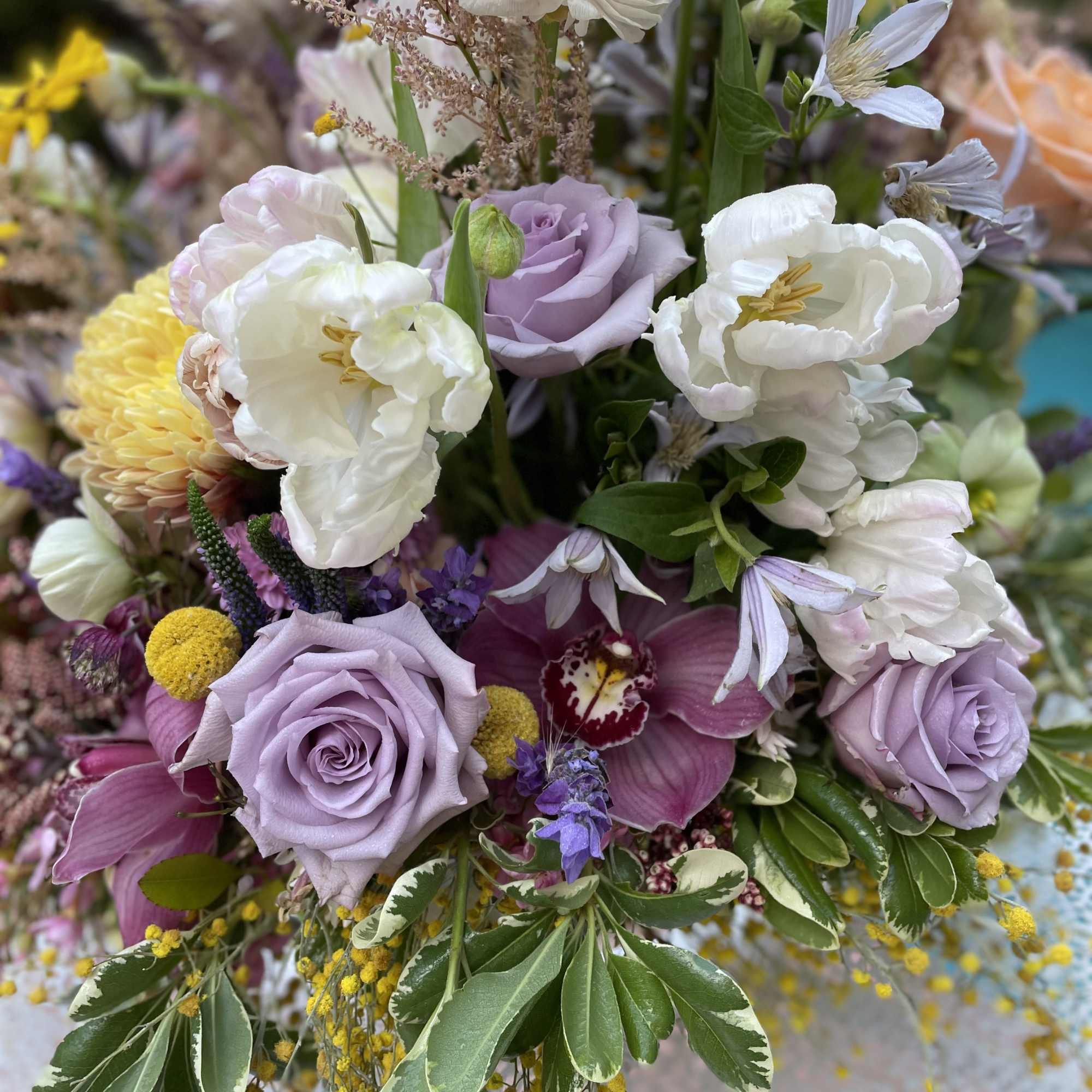 Mixed bouquet with lavender roses, white blooms, and purple orchids