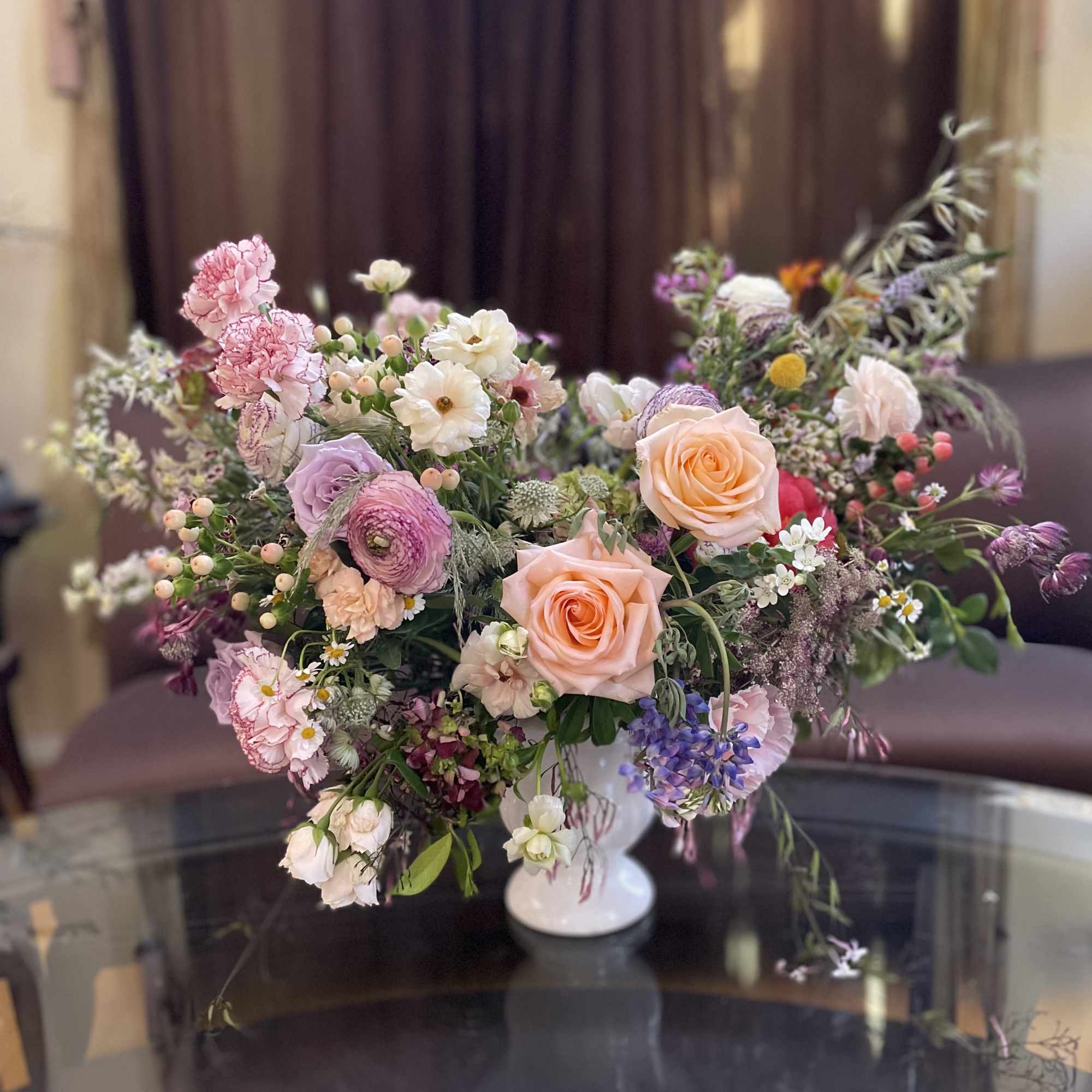 Mixed pastel bouquet in a white pedestal vase