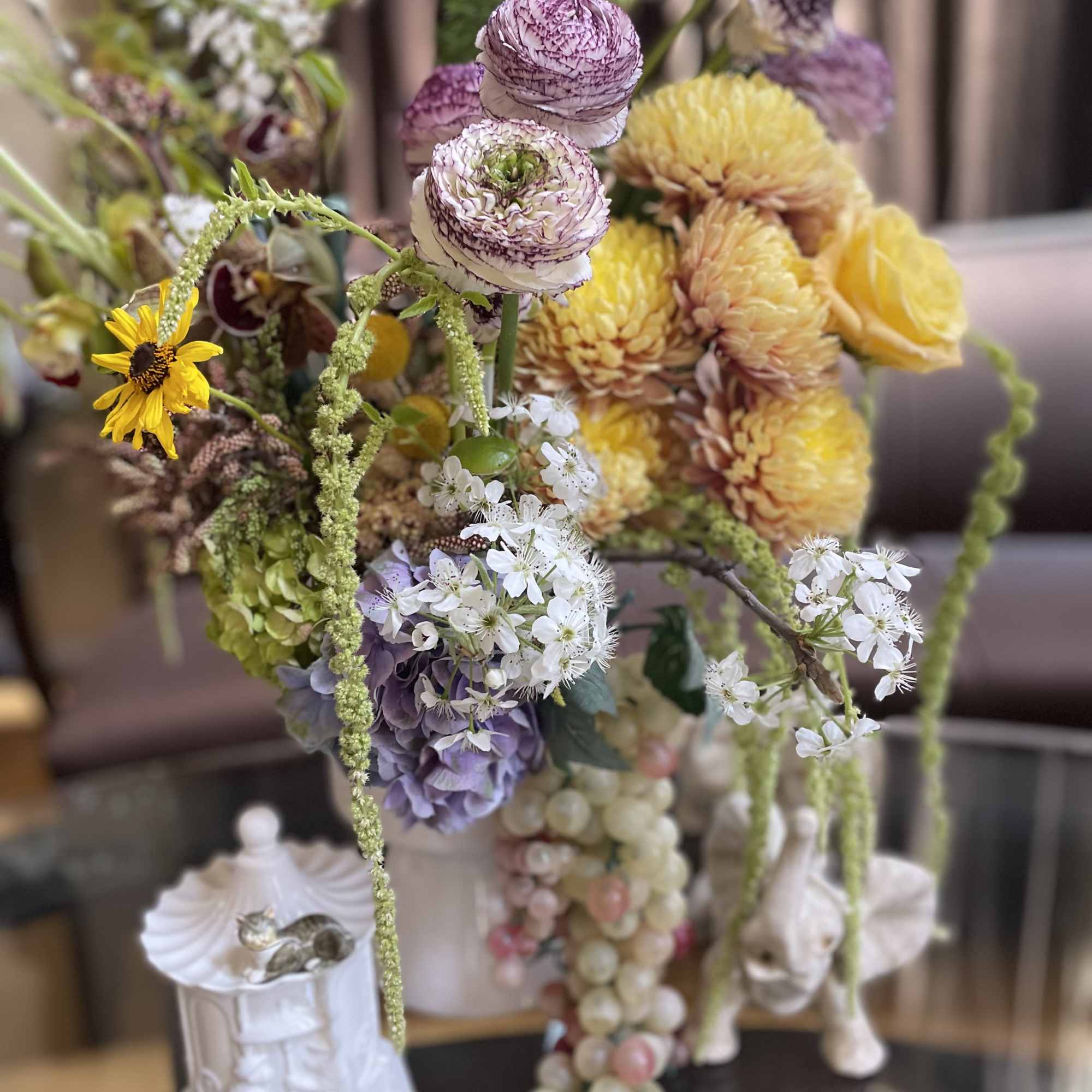 Mixed bouquet with yellow, purple, and white blooms in a decorative vase