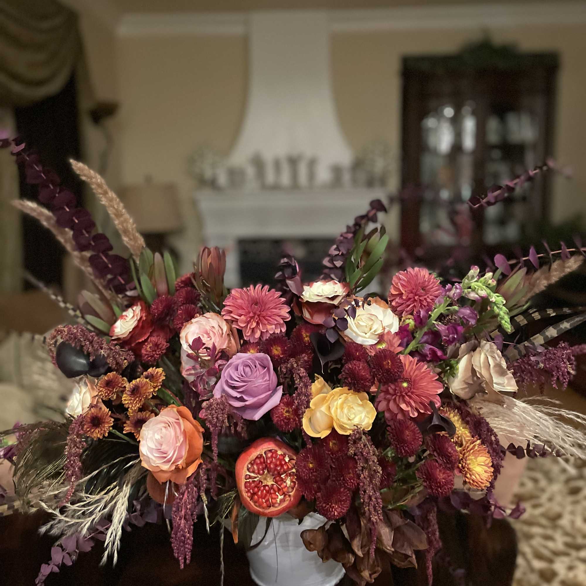 Large mixed bouquet in a white vase with pink, purple, and orange blooms