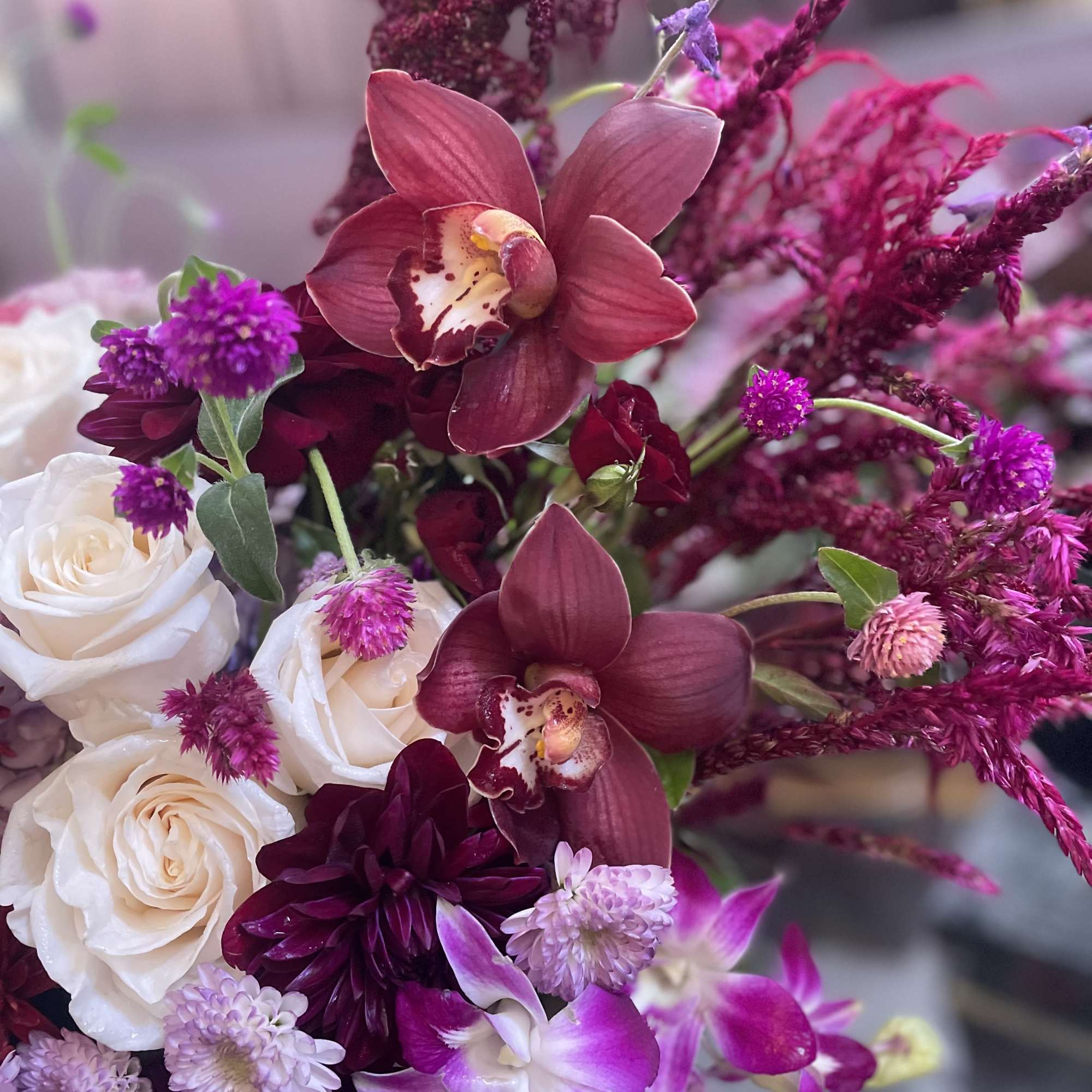 Bouquet of white roses, burgundy orchids, and purple flowers