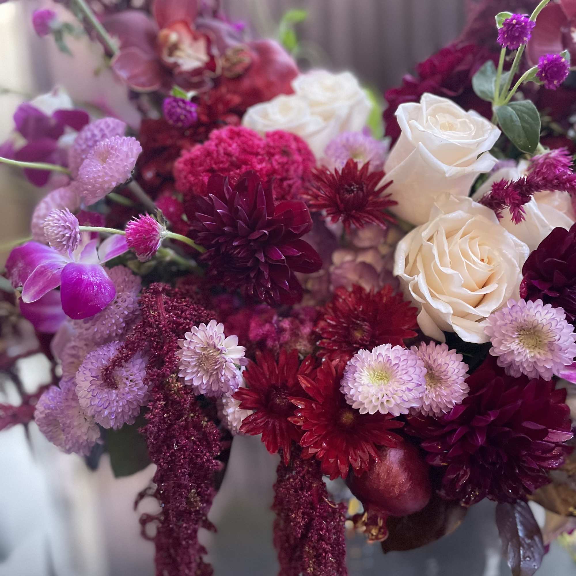 Bouquet of white roses and magenta flowers in pink and burgundy tones