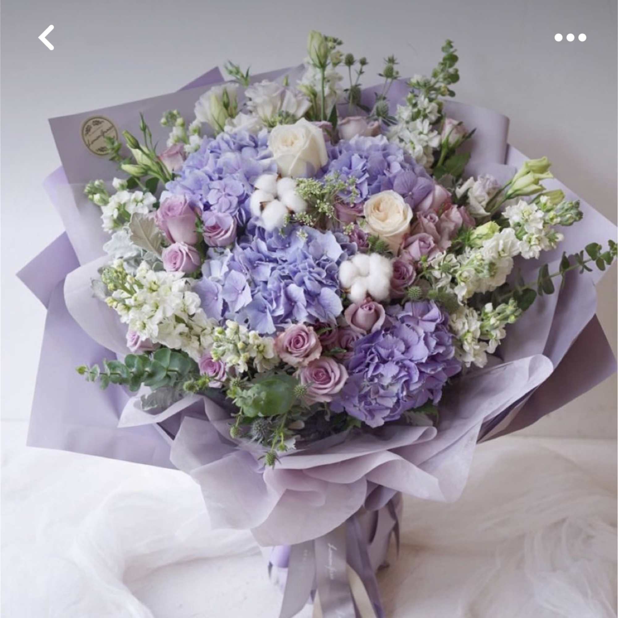 Lavender bouquet with roses and hydrangeas wrapped in lilac paper