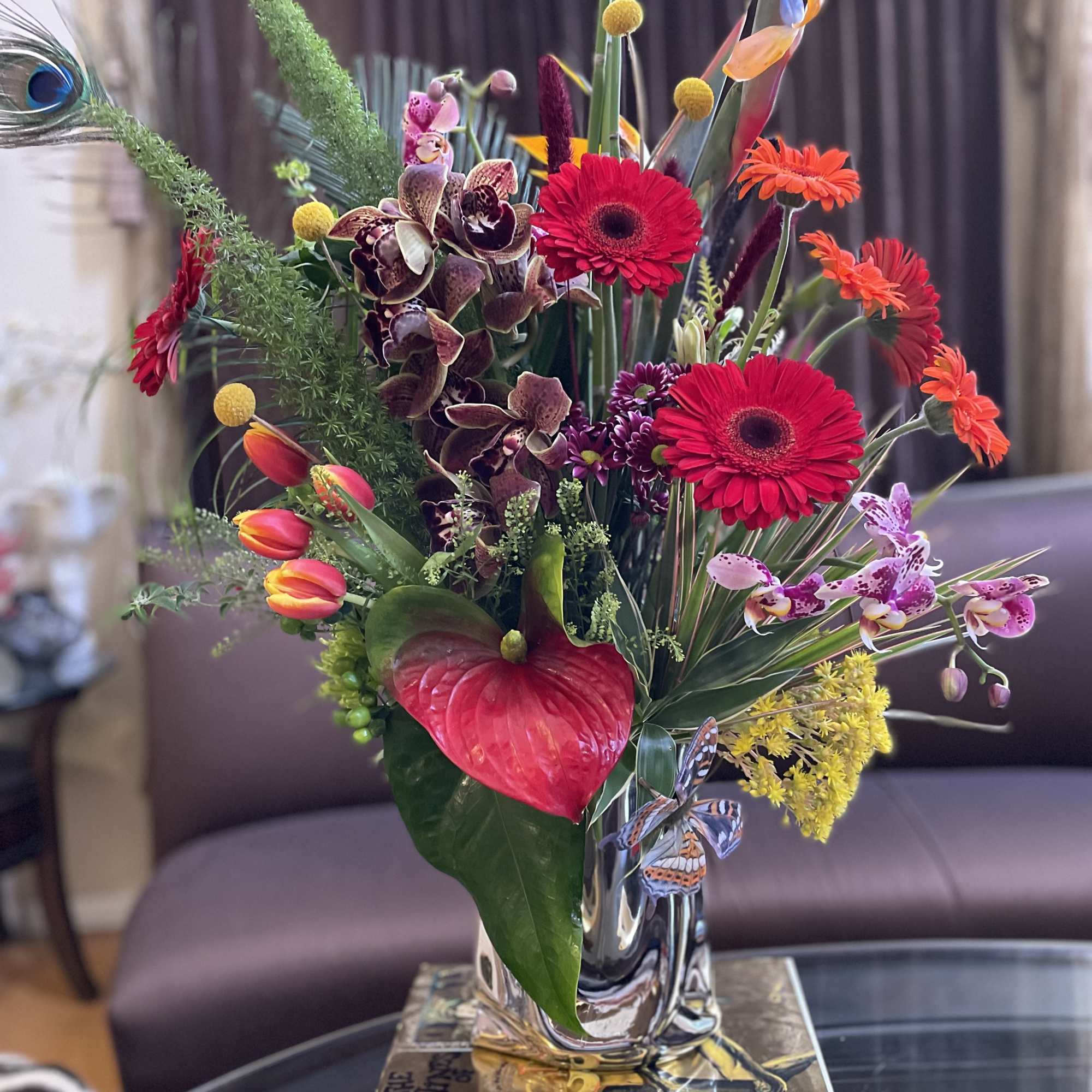 Colorful tropical flower arrangement in a clear glass vase