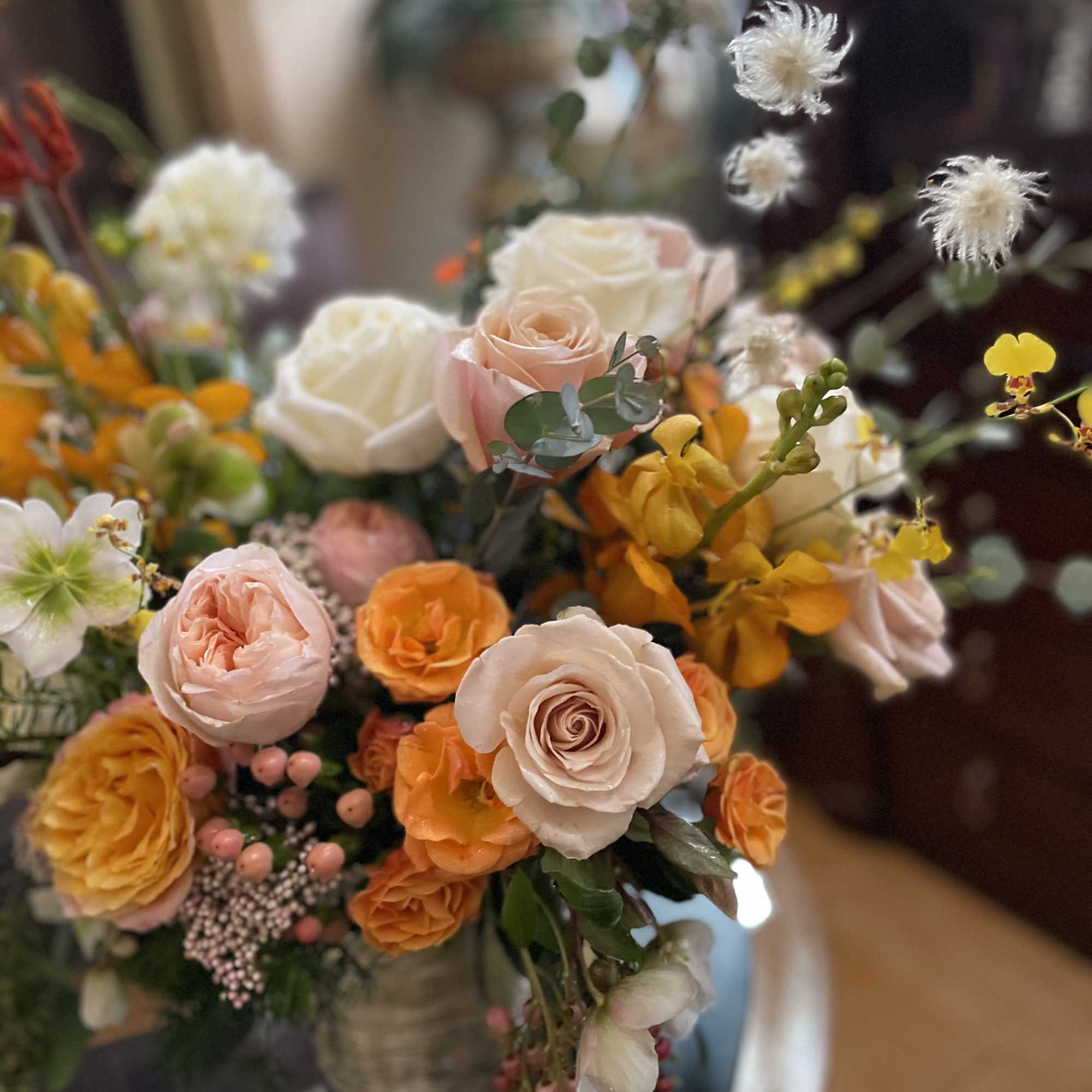 Bouquet of peach, white, and orange roses in a vase
