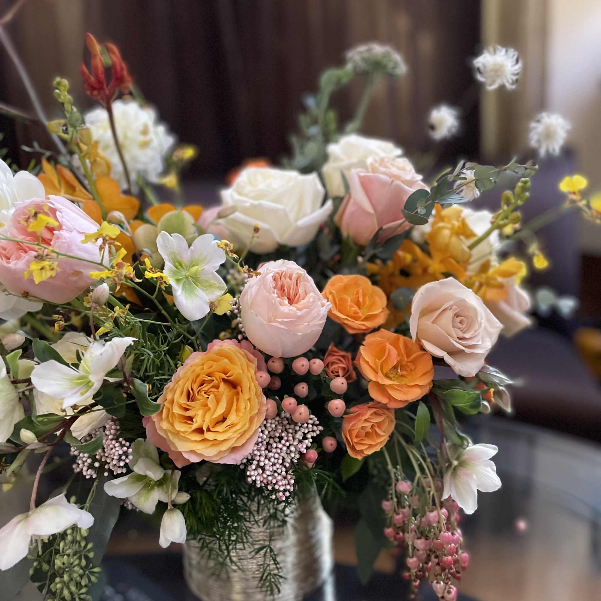 Mixed bouquet of peach, pink, white, and orange flowers in a vase