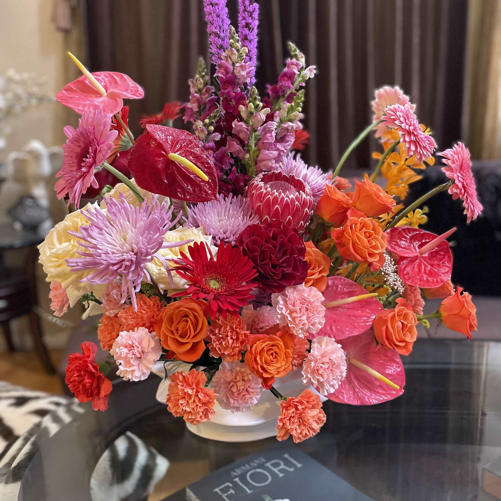 Bright mixed bouquet in a white vase with pink and orange blooms
