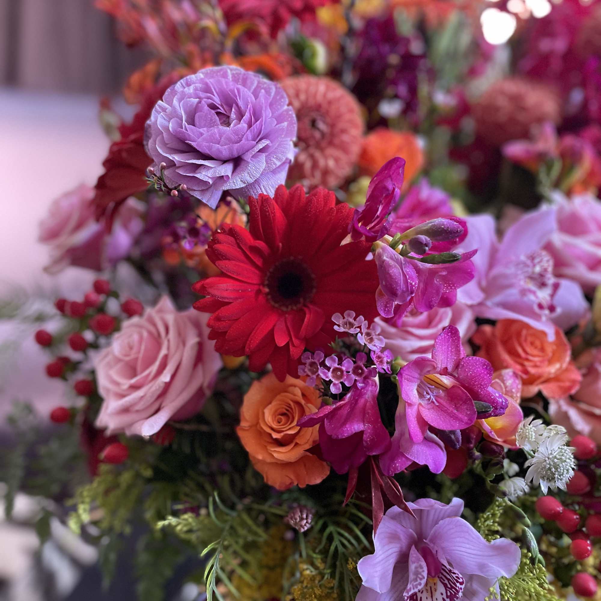 Colorful bouquet with roses, gerbera daisies, and orchids
