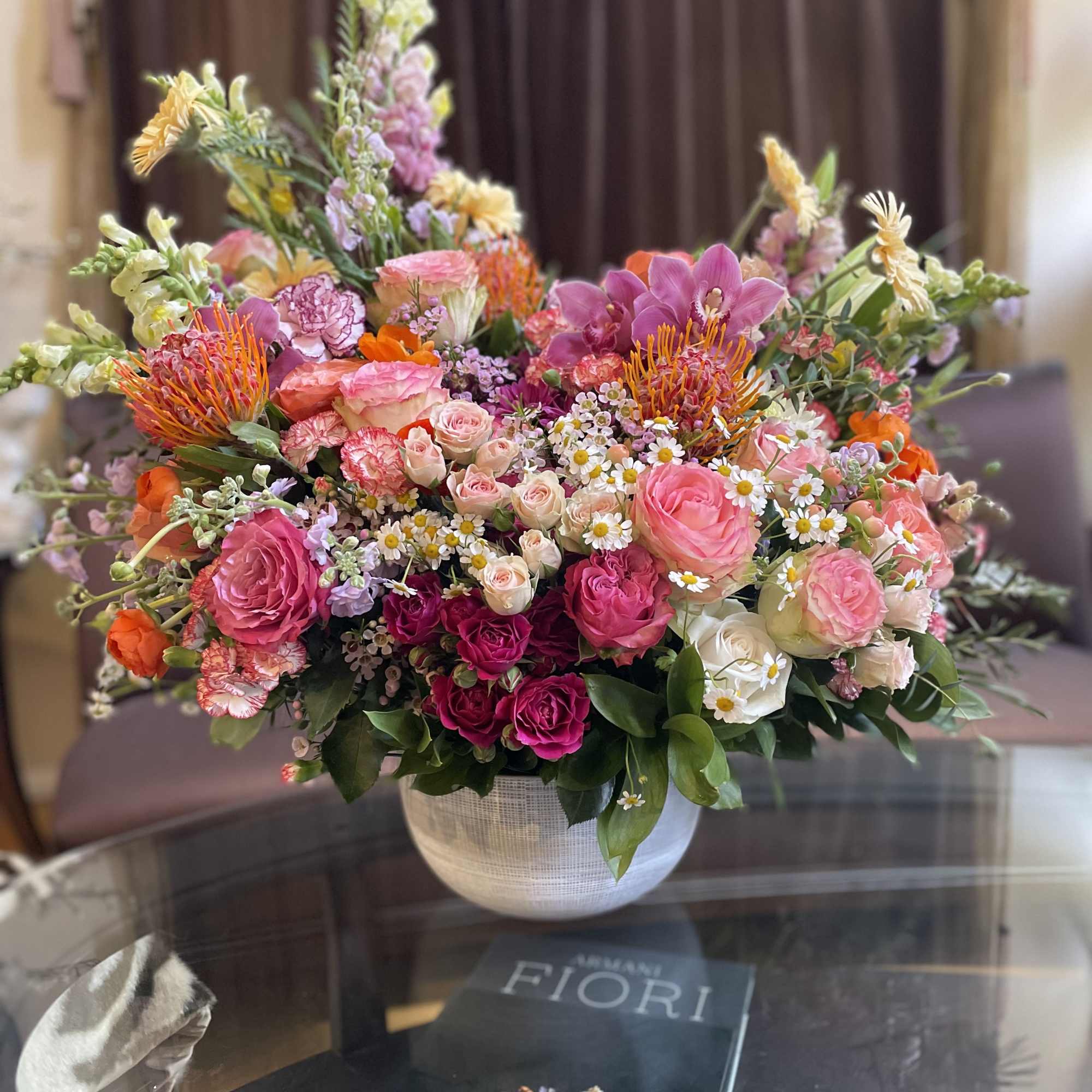 Large mixed bouquet in a white vase with pink, orange, and white blooms