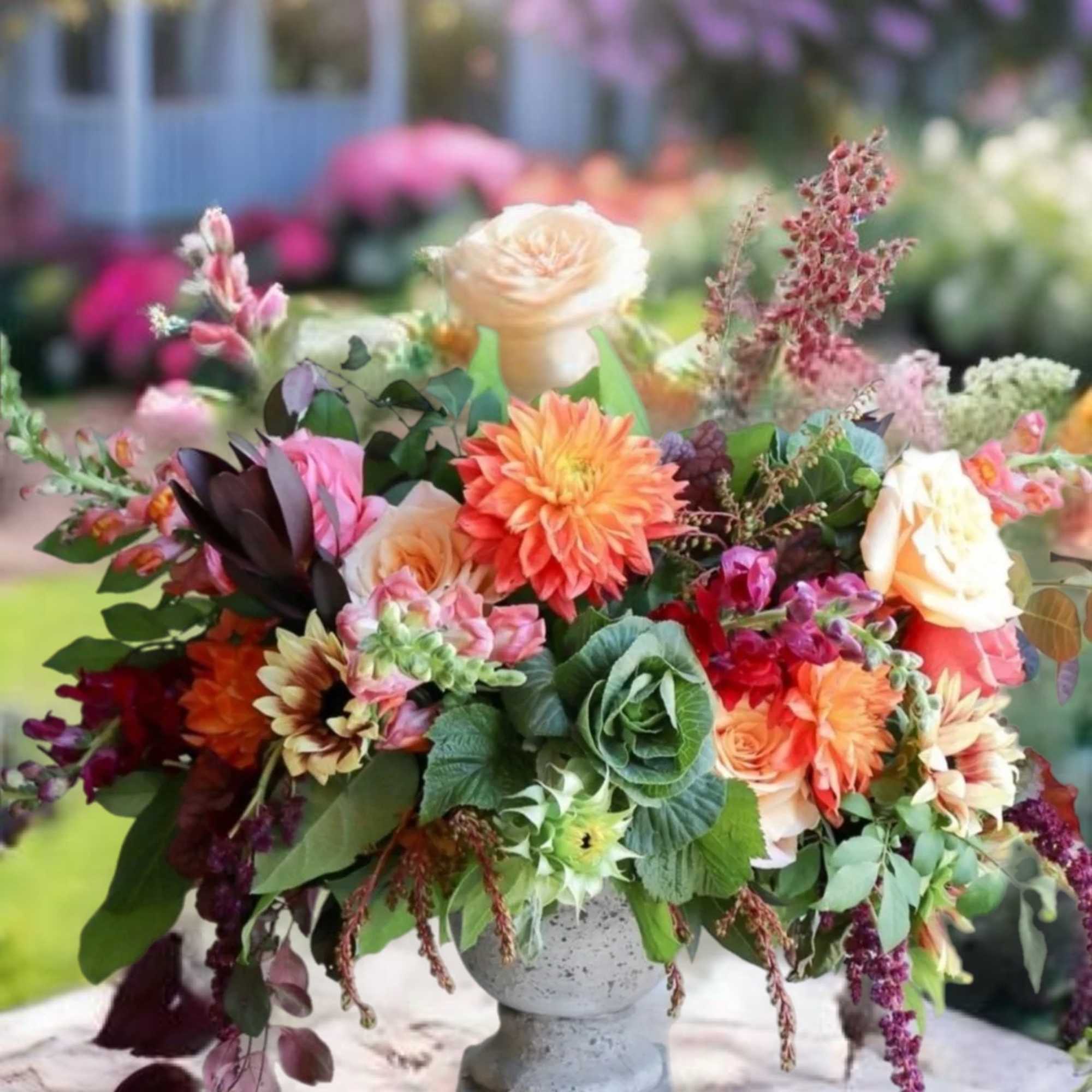 Colorful mixed flower arrangement in a stone pedestal vase