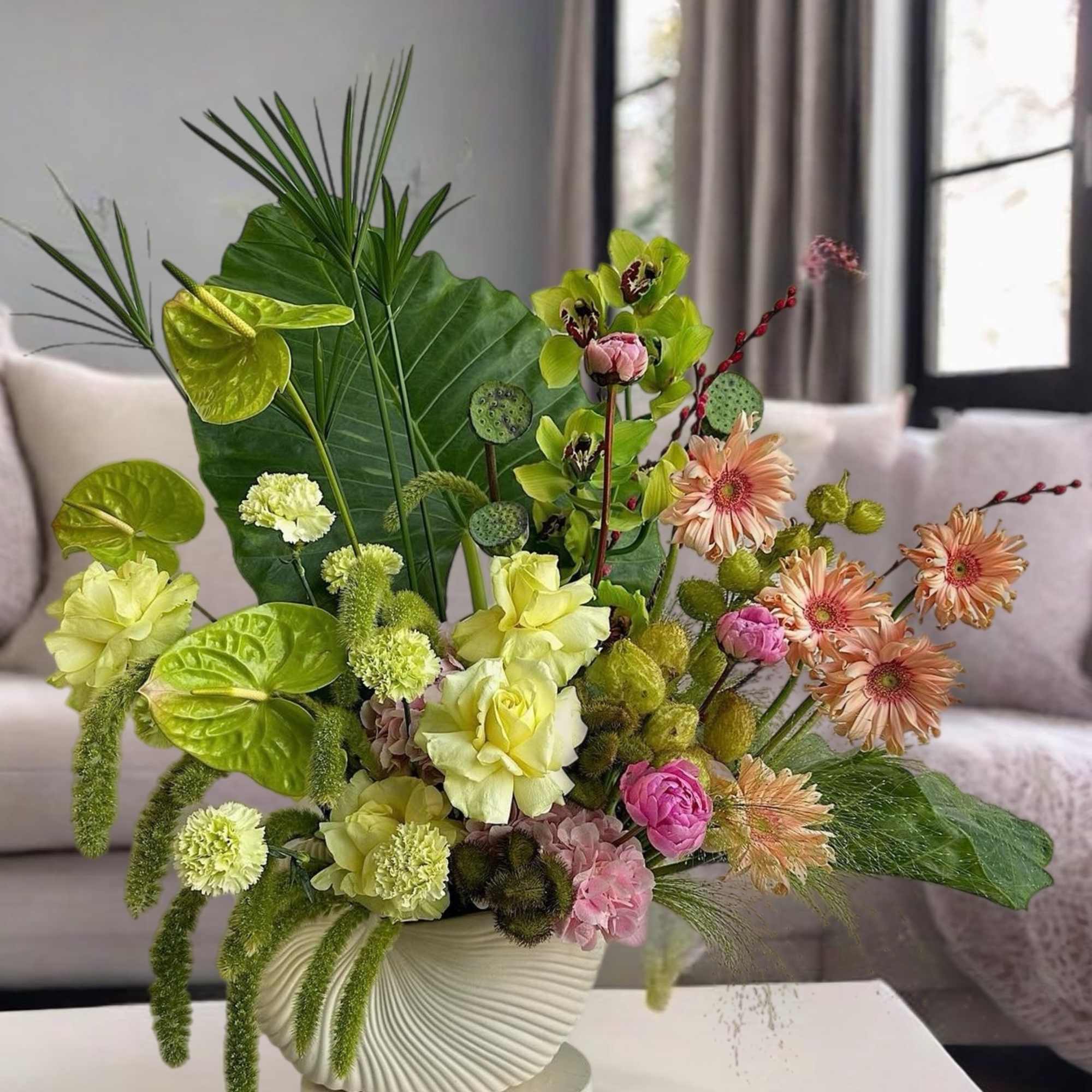 Mixed bouquet in a white ribbed vase with lime and peach flowers