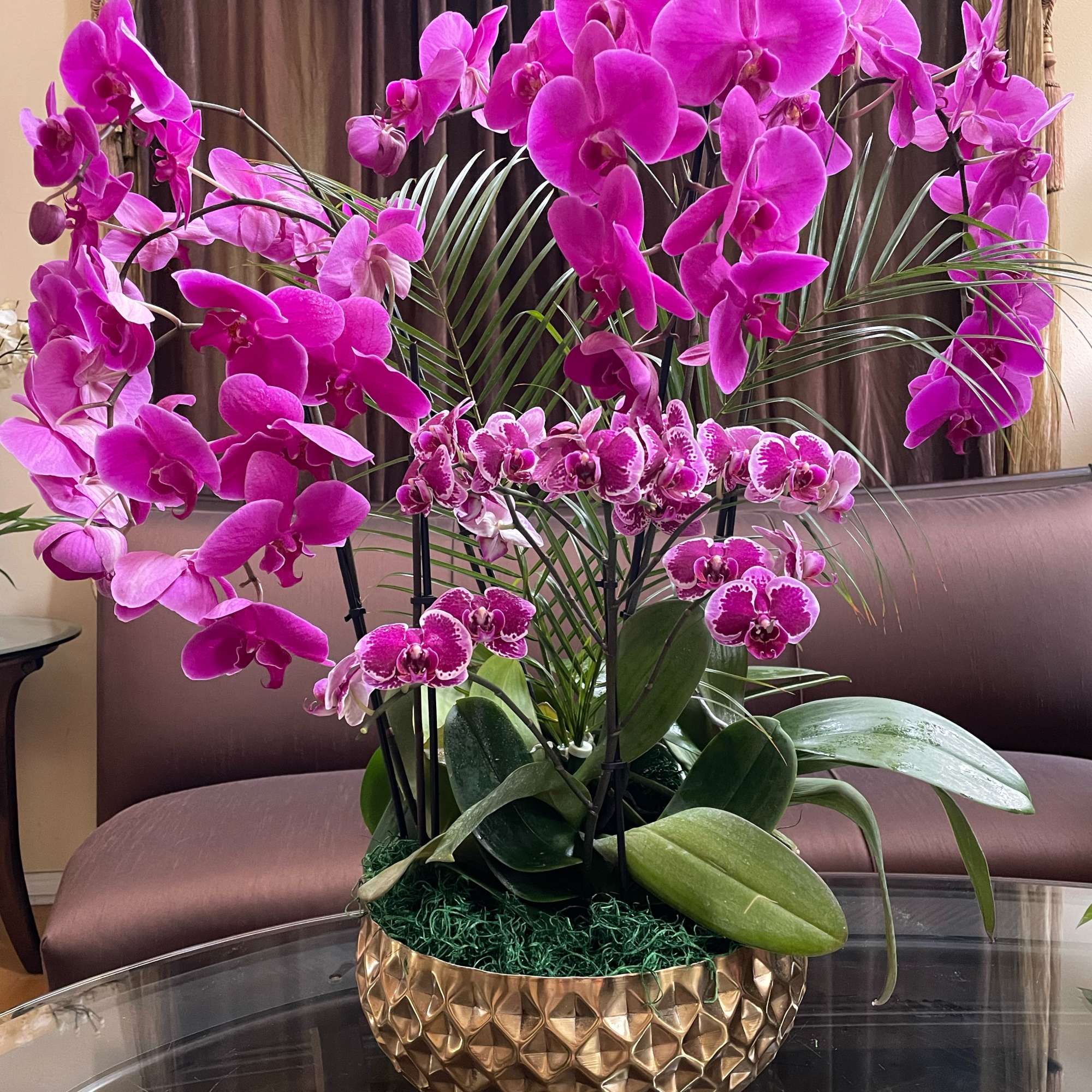 Pink orchid arrangement in a gold textured bowl planter