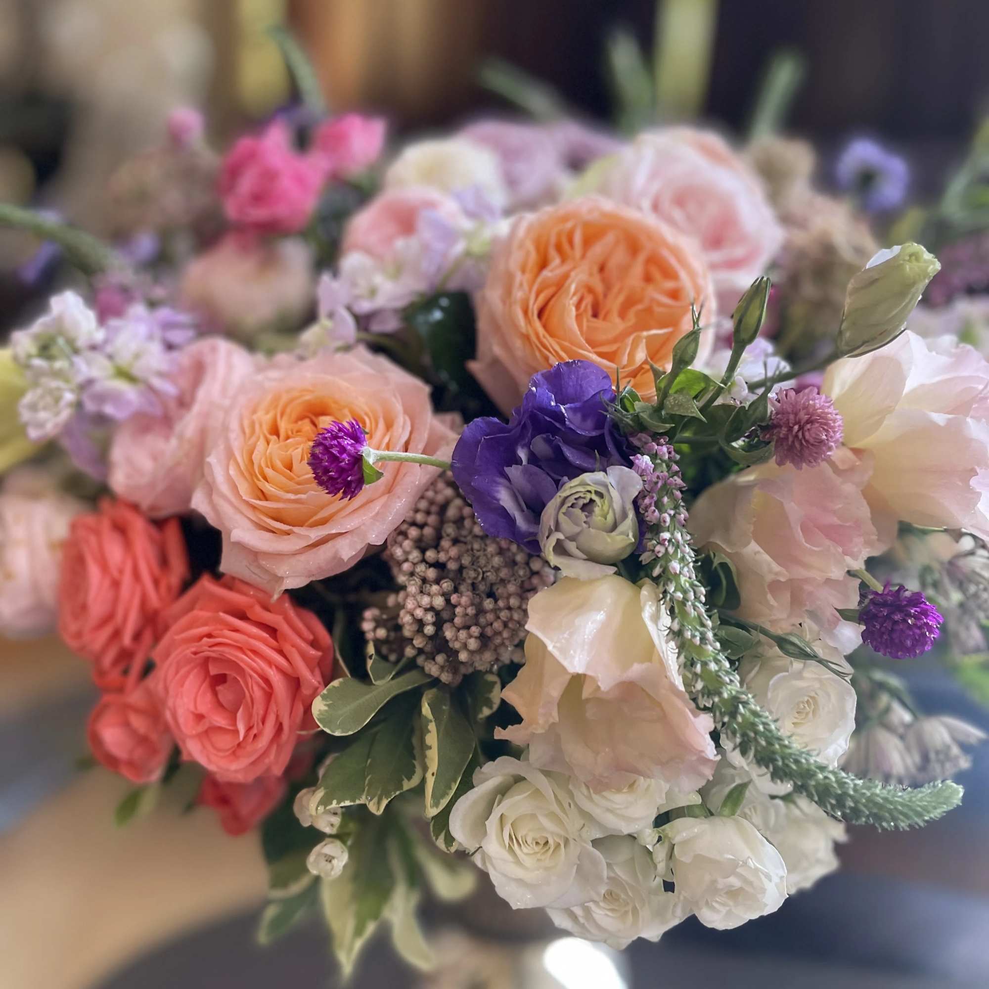 Mixed bouquet of peach, pink, white, and purple flowers