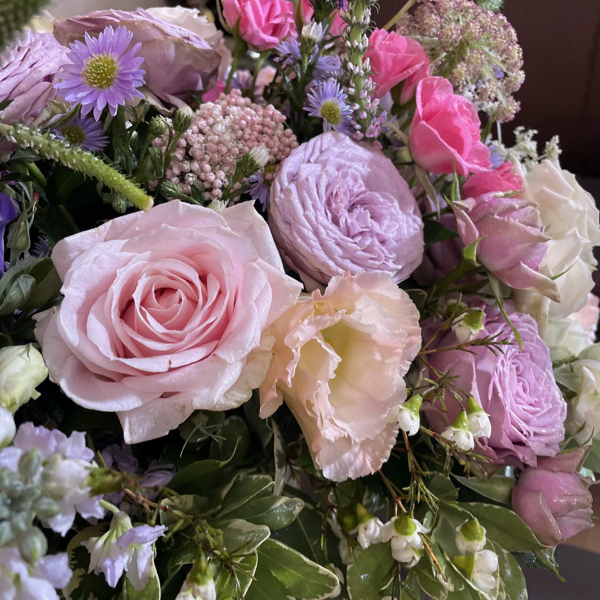 Bouquet of pink and lavender roses with small purple flowers