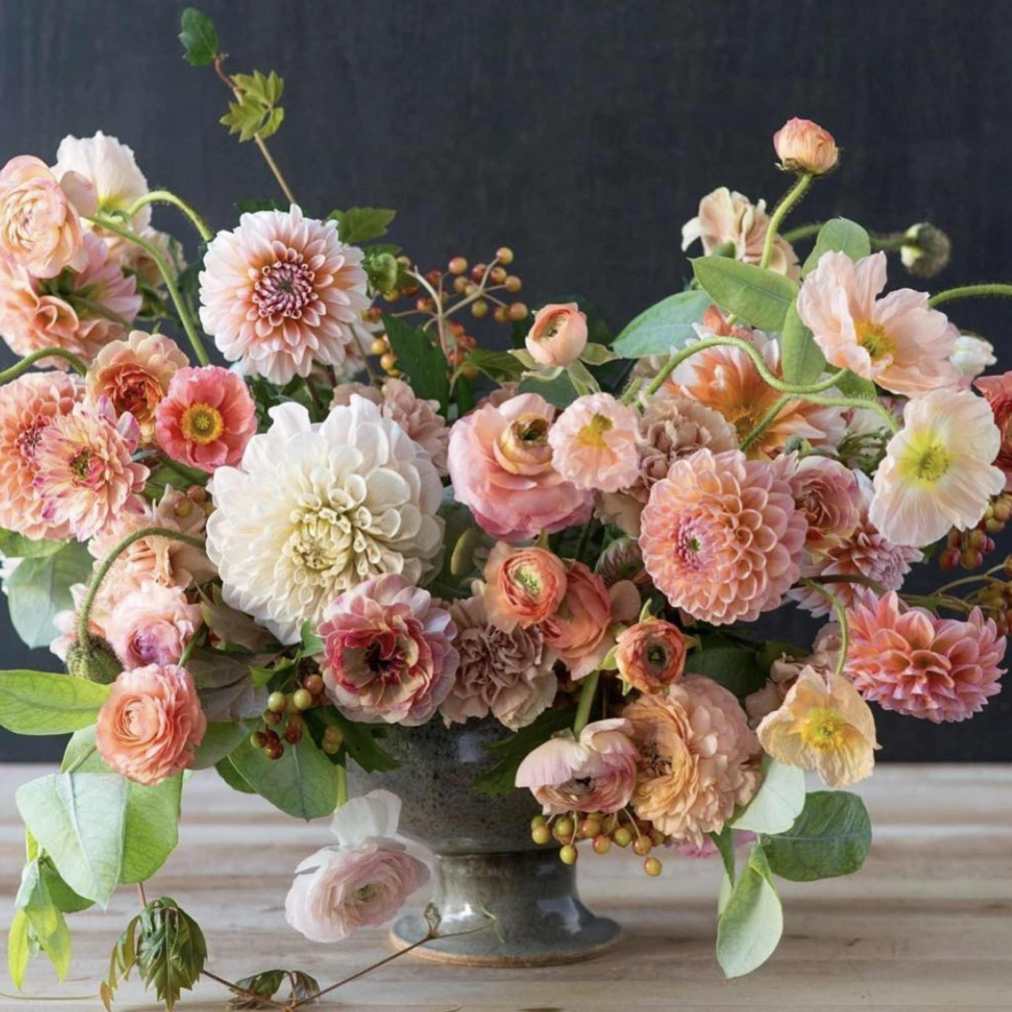 Pastel floral arrangement in a gray pedestal vase