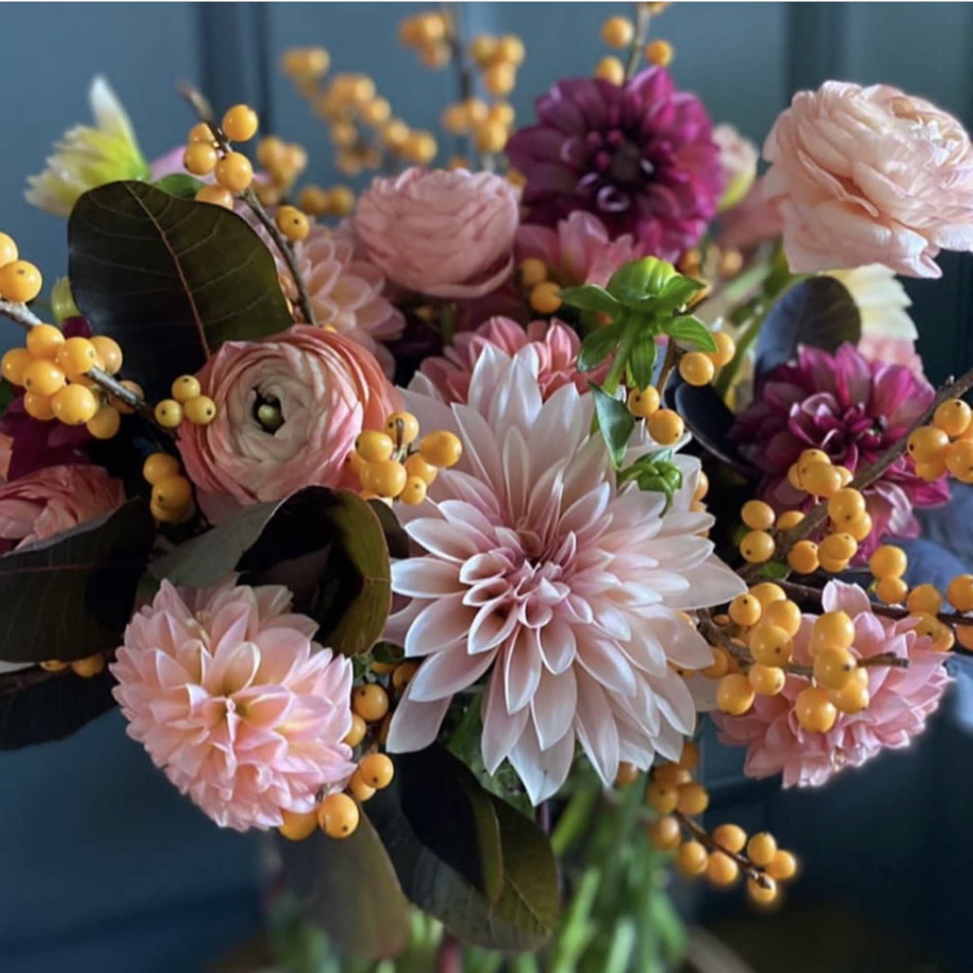 Bouquet of pink and purple flowers with yellow berry sprigs