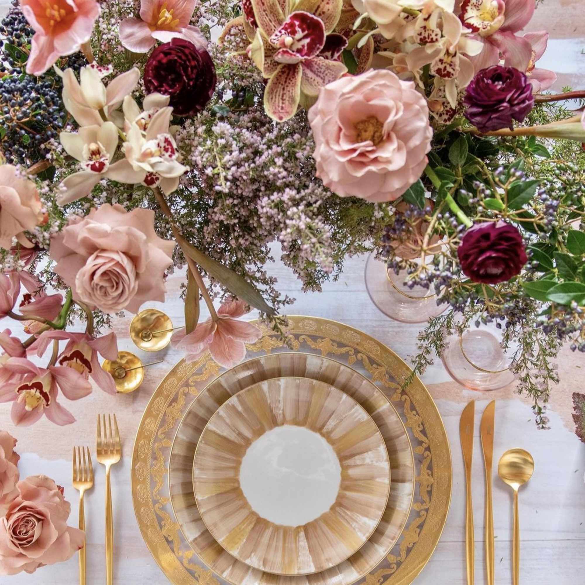 Pink and cream floral centerpiece with gold table settings